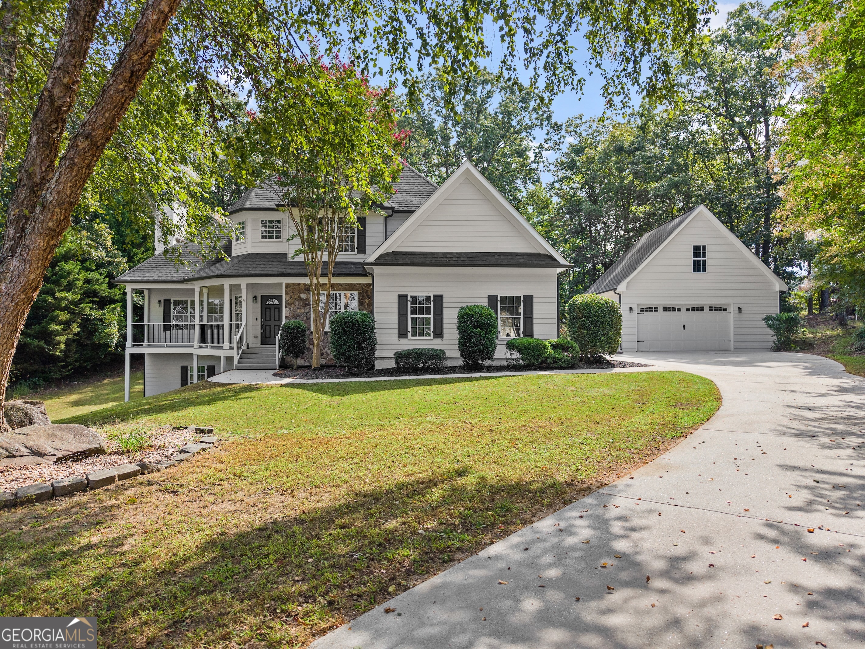 Beautifully Renovated Two-Story Home on a Private Cul-de-Sac Lot with Full Basement & 30x50 Workshop Nestled on a quiet wooded cul-de-sac lot, this completely renovated two-story home offers the perfect blend of modern updates and timeless charm. From the moment you arrive, the inviting covered front porch sets the tone, perfect for relaxing in a rocking chair or swing and enjoying the peaceful surroundings. Inside, you're greeted by a dramatic two-story foyer and stunning real hardwood floors that flow seamlessly throughout the main level. The spacious family room boasts a stacked stone fireplace and plenty of natural light, creating a warm and welcoming atmosphere. Off the family room, a sunroom provides year-round enjoyment and opens to the composite deck overlooking the fenced backyard - ideal for entertaining or unwinding. The completely updated kitchen is a chef's dream, featuring quartz countertops, a tile backsplash, stainless steel appliances, and an open view to the living spaces. A separate dining room offers the perfect setting for hosting family dinners and gatherings. The owner's suite on the main level is a true retreat, showcasing a deep tray ceiling and a luxurious updated bathroom with a frameless glass shower, quartz dual vanity with undermount sinks, and modern fixtures throughout. Upstairs, you'll find three oversized bedrooms, each with walk-in closets, plus a spacious secondary bath featuring a double vanity and a separate tub and toilet room for added convenience. The full daylight basement offers endless possibilities - already partially finished and featuring a walkout, it's perfect for storage, a workshop, a gym, or future expansion. Car enthusiasts, hobbyists, and those needing extra space will love the detached 30x50 workshop equipped with a double garage door in front, single rear entry door, 220v service, mini-split AC, electric heater, and a finished upper level with abundant storage. Additional highlights include: New carpet upstairs All-new fixtures throughout Chain-link fenced backyard with drive-through gate Full composite deck for low-maintenance outdoor living Located in a quiet, established neighborhood close to schools, this home offers easy access to the booming Traditions area, quick routes to Athens via Hwy 129, and convenient commutes to Gwinnett and Atlanta via I-85. This home truly has it all - modern updates, plenty of space, a workshop for all your projects, and an unbeatable location.
