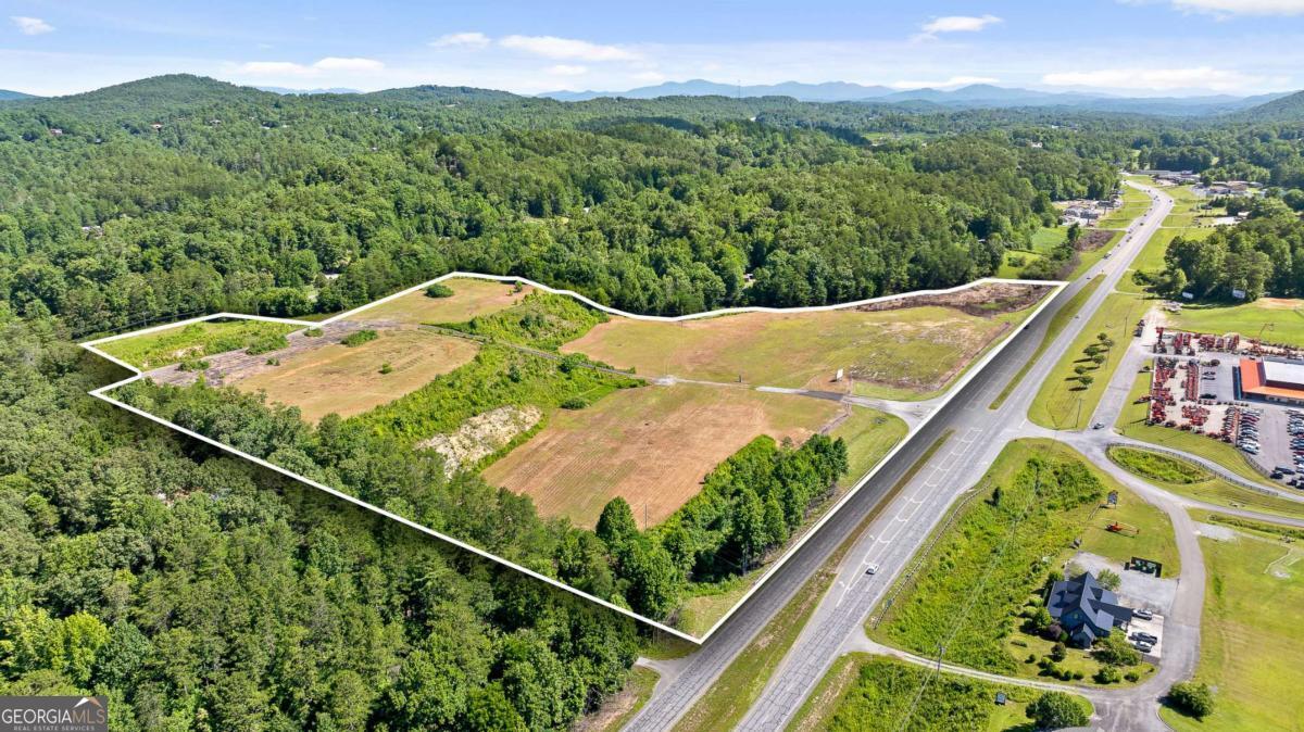 Prime Development Opportunity for Investors & Business Owners - This 24+ acre commercial property offers high visibility and accessibility right off Appalachian Highway. Featuring over 1,600 ft of highway exposure, deceleration lanes and a crossover lane for easy access from both directions on the highway, and a connection to Ballewtown Rd at the back of the property creating the opportunity for two separate entrances/exits. The site has been graded and includes two flat levels with a road connecting the front of the property to the back making it ideal for a wide range of development opportunities. Located just 5 minutes from one of North Georgia's most desirable mountain towns, which attracts both tourists and locals for its shops, restaurants, and historic charm, this is a rare opportunity to acquire a large acreage commercial piece with limitless potential in the evergrowing city of Blue Ridge.