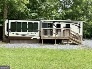 Escape to your ideal mountain retreat or make it your full-time haven in the sought-after Leisure Acres Campground, a gated community in the heart of North Georgia's scenic beauty. This 2013 RV, set on an oversized lot, offers a spacious living experience with a cozy living room, a kitchen featuring an island and ample cabinet space, a bathroom with a standalone full shower, and a master bedroom. The inviting outdoor porch is perfect for soaking in the fresh mountain air. This oversized lot provides room for gardening and outdoor avtivities/hobbies. Leisure Acres is a beloved destination for family and friends, boasting amenities like a fishing pond, playground, and community pool. Conveniently located near shopping, restaurants, and attractions such as local wineries, Helen, waterfalls, and hiking trails, this location offers the perfect blend of relaxation and adventure.