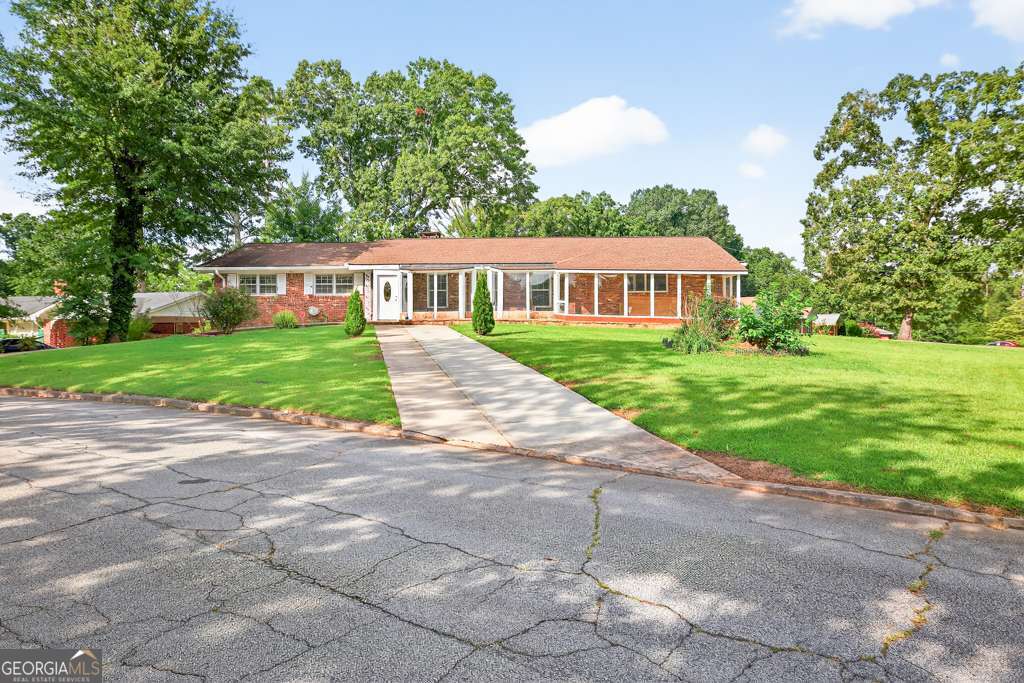 Beautifully updated ranch-style home in Stone Mountain on a spacious 0.4-acre corner lot. This 4-bedroom, 2-bath property features a family room that flows into the kitchen, a great room with open-concept dining, a dedicated laundry/utility room, and ample closet space. Enjoy both an enclosed porch and a new open deck, perfect for outdoor living. Recent updates include: new interior paint, new waterproof laminate flooring, fully renovated bathrooms, new gutters, and a new deck. Exterior highlights include three driveways with abundant parking, a large front yard, and a fenced backyard. Conveniently located within walking distance of Georgia Perimeter College (now part of Georgia State University), and close to Piedmont Technical College and UEI College. Easy access to I-285 makes commuting to Stone Mountain, Decatur, and Atlanta simple. This move-in ready home combines modern updates with a prime location-schedule your showing today.