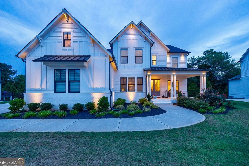 This stunning custom-built home offers the largest floor plan in the exclusive gated community of Tanglewood Enclave. You will love the privacy this home site offers with large Evergreen trees yet is large enough for your own personal pool if desired! From the moment you step onto the front porch, you'll admire the herringbone brickwork and elegant double French doors. Inside, every corner is adorned with designer finishes that add to the home's exceptional charm. The kitchen is a chef's paradise, featuring a farmhouse sink, oversized island, stacked glass-front cabinetry, spacious soft close drawers, and high-end appliances. Cooking becomes a joy with the 48" Monogram built-in stainless-steel refrigerator, 48" Monogram gas cooktop with griddle, double ovens, microwave drawer, and pot filler. The Two-story Great Room opens to a covered deck with retractable screens for versatile indoor-outdoor living. Upstairs, the owner's suite is a serene retreat with a spa-like bathroom, including a freestanding tub, dual-entry oversized shower with multiple shower heads, benches, and niches. The custom walk-in closet is fitted with built-ins, lights, and mirrors to meet every need. Each secondary bedroom includes an ensuite bath and walk-in closet. The finished basement offers additional living space perfect for entertaining or a private getaway, complete with a large bar featuring an island, sink, dual undercounter refrigerators, custom glass cabinetry, and quartz countertops. Thoughtful trim work adds elegance throughout the home. This one-of-a-kind custom design is truly unparalleled.