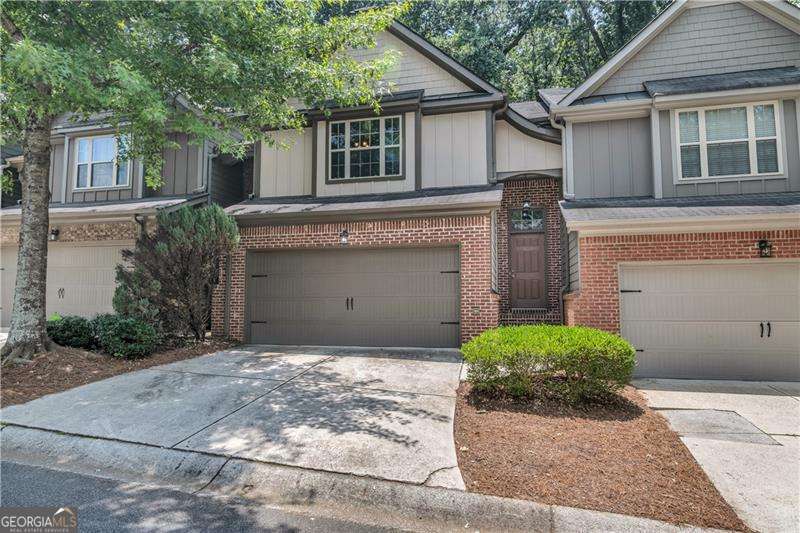 Welcome home to this ready-to-move-into townhome in a quiet, gated Marietta community! This meticulously cared-for residence boasts all-new flooring and interior paint for a fresh start. You'll love the open-concept main level, featuring durable LVP flooring in the family room, complete with a cozy fireplace. The dining area offers pleasant views of your private back patio. The adjoining kitchen is a chef's delight, showcasing stainless steel and black appliances, and High-Performance Laminate countertops with ample cabinet storage. Upstairs, the primary suite offers a peaceful retreat with a charming trey ceiling, an adjoining bath, and a generously sized walk-in closet. Two additional bedrooms and a secondary bath provide flexible space, perfect for guests, family, or dedicated home offices. Step outside to your private patio, which overlooks serene woods and includes an exterior storage closet. The two-car front-entry garage provides plenty of space and an additional storage closet. Enjoy peace of mind with low HOA fees that cover water, sewer, exterior dwelling, grounds & road maintenance, trash, pool, termite control, fire & common area insurance, and HOA management services.