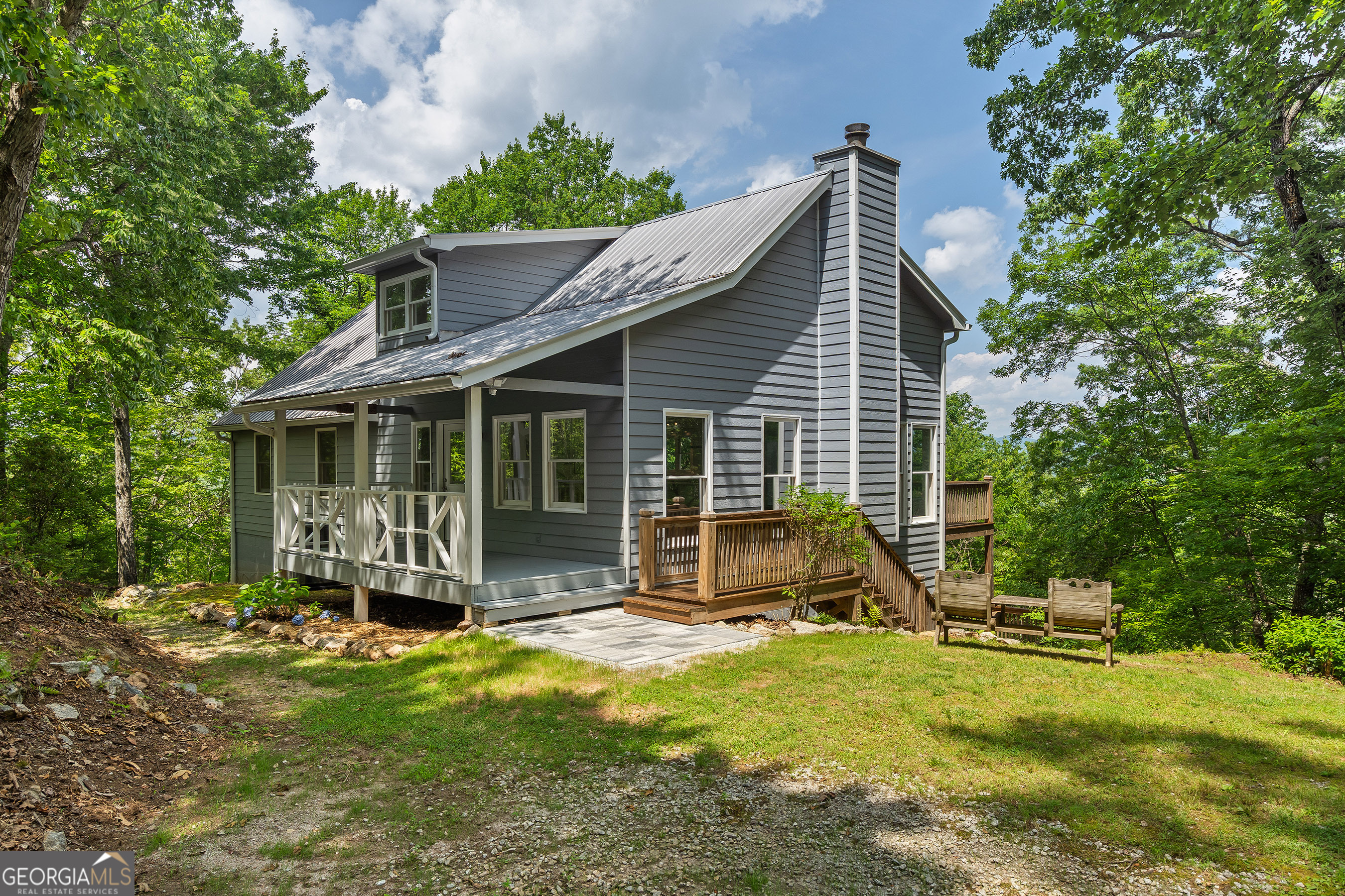 If you're seeking a private retreat with beautiful mountain views, look no further! This 3-BR, 3-BA home with a loft is located in the Round Top Mountain community with close proximity to downtown Clayton and Heaven's Landing, ideal for aviation enthusiasts. Meander a paved road to the mountain top to find this scenic getaway. A covered porch welcomes you to step inside the open concept living room/dining room with abundant natural light, vaulted ceilings, and a masonry fireplace. The heart of the home is the fully renovated European designed chef's kitchen-complete with sleek natural stone countertops, all new appliances, a 5-burner gas range and hood, breakfast bar island, wine and beer cooler, soft-close cabinetry, and a spacious pantry. Unwind or entertain on the expansive wraparound double deck, stretching the full length of the home and offering jaw-dropping mountain views. The main-level, primary bedroom complete with an ensuite bathroom features a new double vanity, tiled shower, and separate soaking tub. A second main-level bedroom and bathroom have been thoughtfully redesigned for maximum comfort and flow. Upstairs, a versatile loft space is perfect for a home office, studio, or hobby room. Downstairs, guests will enjoy their own private space with a bedroom, full bathroom, and cozy living area. Additional upgrades and features include: New $15,000 Trane HVAC system, Industrial-grade dehumidifier, new lighting fixtures, professionally refinished wood flooring, new toilets and bathroom cabinets, new interior paint and decking sealer. Enjoy consistent high-speed internet with G5 Wi-Fi coverage. The Round Top Mountain community is located within a 10-minute drive to downtown Clayton and a 15-minute drive to Lake Burton.