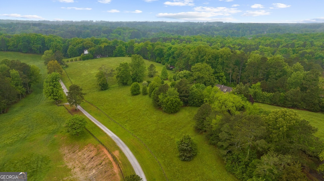 Rare opportunity to own 4.89 acres in sought-after Southeast Cherokee County with an Alpharetta address. This exceptional property sits atop a gently rolling hill and offers stunning panoramic views of the surrounding countryside. A mix of open pasture and mature hardwoods provides both beauty and versatility, creating the perfect canvas for your private estate. Whether you dream of building a peaceful retreat or developing a residence tailored to your lifestyle, this tract delivers endless potential all just minutes from top-rated schools, shopping, and dining.