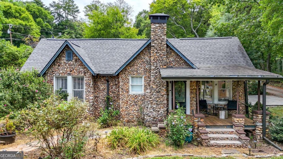 Brimming with character and charm, this 1920s rock exterior cottage offers just under 1,000 sq. ft. of thoughtfully designed living space. Step inside to find beautiful hardwood floors, a rock-face fireplace that serves as the heart of the living area, and an updated kitchen with stainless steel appliances that blend modern convenience with timeless appeal. The primary bedroom comfortably fits a king-sized bed, and the guest bedroom provides just the right amount of space for visitors, a home office, or a creative space. Outside, you'll appreciate the detached garage for additional parking or storage, space for a garden, and a covered front porch and covered back patio - perfect for relaxing or entertaining once refreshed. With new exterior doors arriving August 20th and years of careful upkeep, this home pairs historic charm with modern touches in an easy-to-maintain size you'll love coming home to.