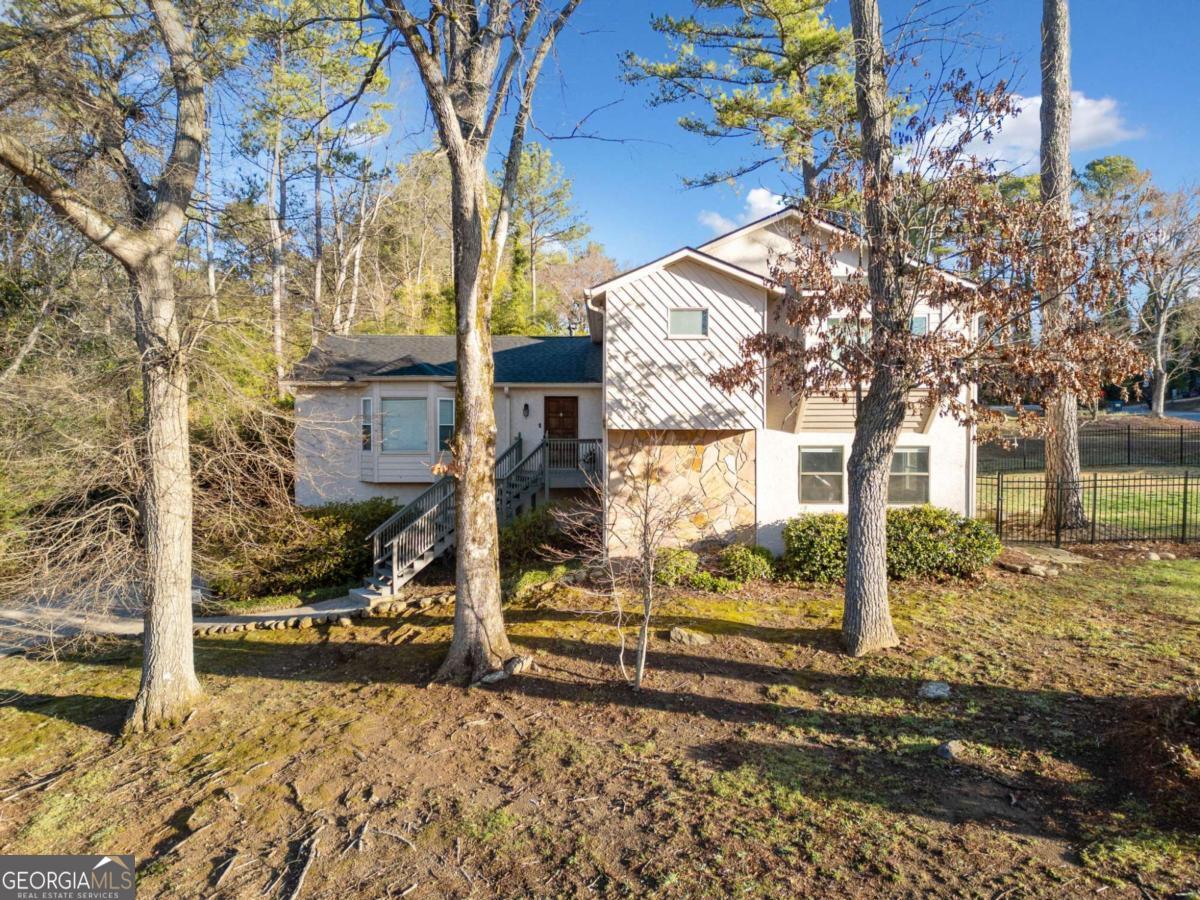 Renovated contemporary Home in prime East Cobb Location. As you enter the home, you are greeted by a large living room and dining room. As you continue to the back of the house, you will find an eat-in kitchen with white cabinetry, granite countertops, and updated appliances. Off the kitchen is a sliding door with access to the back deck. Upstairs, the primary suite includes a walk-in closet and renovated ensuite bath with a double vanity, soaking tub, and separate shower. Three secondary baths share a renovated hallway bathroom. A few steps down from the kitchen is a family room featuring a cozy fireplace and built-in bookcases on either side, providing ample storage. The lower level also includes an additional bedroom, bonus room, or in-law suite with a full bathroom. Outside, you can enjoy almost half an acre yard, a new wrought iron fence, and a back deck. The two-car garage offers additional storage, and the large driveway provides extra parking. New roof installed in 2022! Located in the Sprayberry High School District. Country Plantation amenities include a Pool, Tennis, and a playground within walking distance of the home.