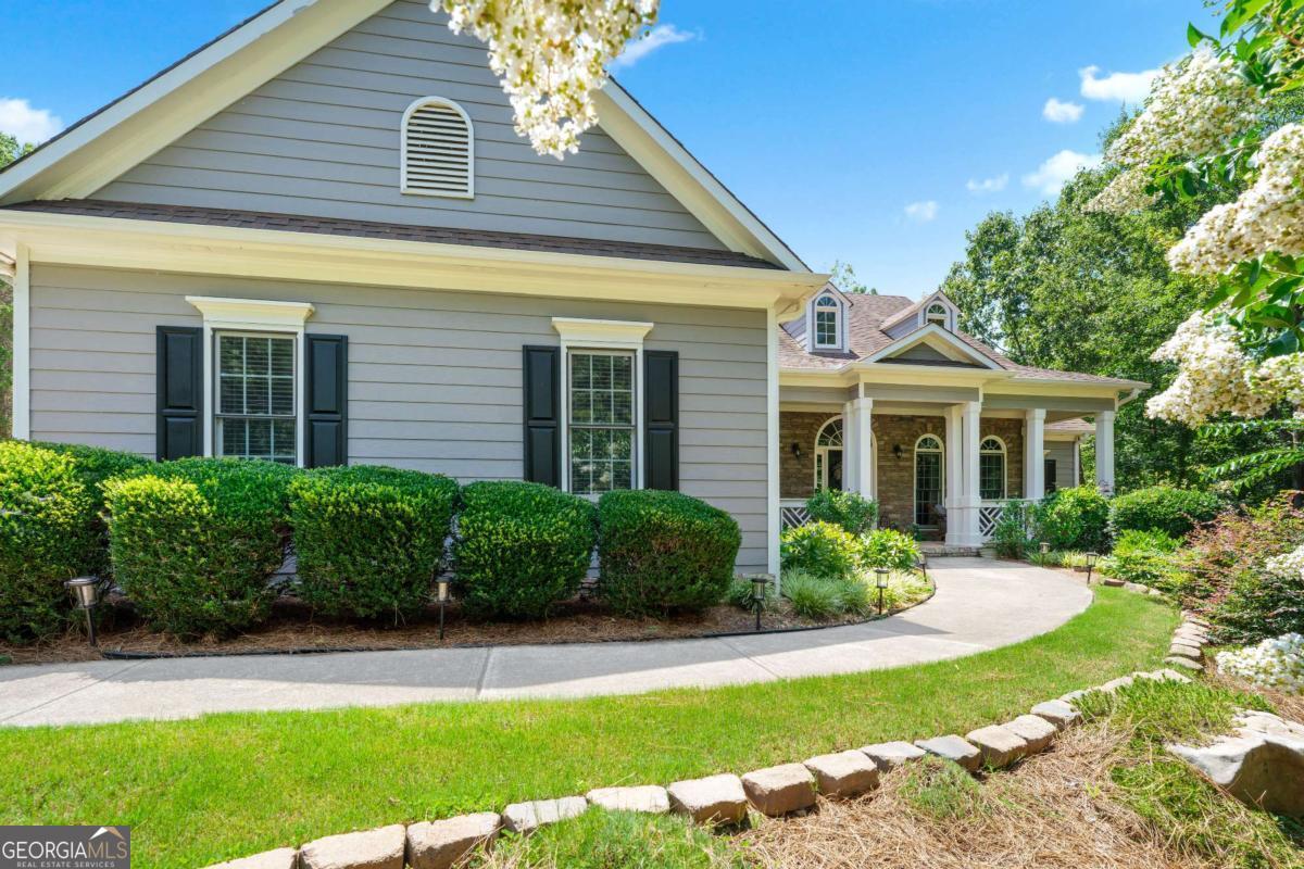 Rare find in Sweetwater Creek subdivision! Welcome home to this custom-built, one-owner RANCH on a FULL daylight BASEMENT, perfectly positioned on a large, private lot backing up to Sweetwater Park on Lake Allatoona-just a short walk to the lake! This 4-bedroom, 3.5-bath home features a separate dining room, office/formal living room, and family room with soaring coffered ceilings and a stone fireplace, open to a breakfast room and gourmet kitchen with granite countertops, stainless steel appliances, and plenty of storage. The primary suite on the main includes a vaulted tray ceiling and a beautifully updated ensuite bath with double vanity, separate whirlpool tub, glass shower, and a large closet. Two additional bedrooms and a full bath are on the main floor, and just off the laundry area, a private staircase leads to the bonus fourth bedroom and full bath upstairs, along with easy attic storage access. The main-level laundry room includes a sink and built-in cabinetry for added convenience. An extra-large two-car garage with side entry door offers easy access, and ample driveway parking offers convenience for family and guests. Additional features include hardwood floors, beautiful crown molding, a sun porch/screened porch and sundeck area, plus a LARGE unfinished basement stubbed for a bath with a fantastic layout for future finishing. The basement also features two sets of French doors and two breaker boxes. The backyard is private and level, with a generous patio for more outdoor entertaining. Privately situated on a manicured lot with mature trees and a welcoming rocking chair front porch, this home is just minutes from Lake Allatoona, Sweetwater Creek State Park, and all the amenities Cherokee County has to offer.