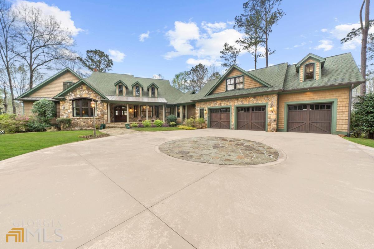 LAKE FRONT ESTATE LOCATED ON A COVE IN THE TRANQUIL AND PRESTIGIOUS ENCLAVE OF GREAT WATERS AT REYNOLDS LAKE OCONEE. Exquisitely detailed throughout, including immaculate woodwork and moldings. Custom designed and crafted by a Master Artisan. Home has extensive use of reclaimed antique heart pine throughout, including hand-crafted flooring and structural beams and ceilings. The use of rare antique elements throughout the house gives this home its ambiance and Old World feel that is difficult to replicate. The open concept kitchen is well designed with ease of entertaining in mind. It includes a custom designed LaCanche French Range, flamed and brushed granite countertops, Carrara Marble accents, as well as a large island magnificently crowned with rare living edge African Rosewood. Commercial refrigeration and a true, fully equipped butler's pantry makes this kitchen ready for any crowd, big or small. Bi-fold doors opens up the great room to the extensive open decks with a spectacular view across the lake. A four-season screened porch features a stone fireplace (one of 3) with a wood-burning pizza oven. The primary bedroom suite is on the main level and features a sitting area and a bath with a freestanding tub. The additional bedrooms in the house all include ensuite bathrooms. Also, above the garage, there is a full bedroom suite with a full kitchen, living room, full bath, closet, and its own A/C. Included in the basement is a multi purpose room, theatre, wine room, an additional mini-kitchen and multiple storage areas.