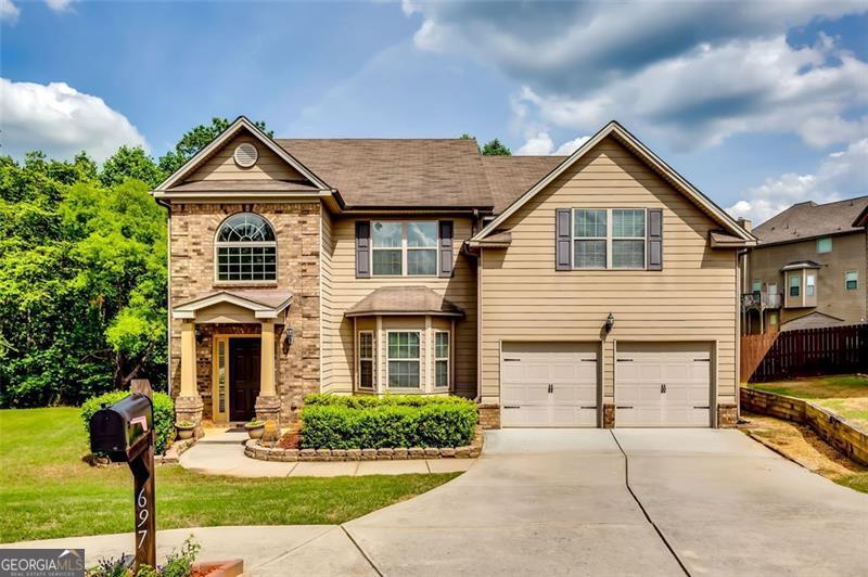 After a long day, this home will welcome you to peace and tranquility inside and out! Located in the Overlook at Camp Creek community, nestled on a quiet Cul de sac, is a 5-bedroom 3 full bath sanctuary. This two-level home offers space and versatility to meet your comfort and needs. Allow your senses to be intrigued with high ceilings, natural light throughout, ample space to entertain in the separate dining room or by the beautiful stone wood burning fireplace in the living room, and an eat in kitchen with breakfast bar. Functionality is here! Summer nights or not, grilling is made easy with direct kitchen access to the covered patio. Create an outdoor living space of choice accented with blueberry bushes, pear trees and grape vines there right now, waiting for you. If rest and relaxation is what you need, that is what you will get! On the upper level, the oversized primary bedroom and ensuite bathroom makes for the perfect oasis. A separate shower and garden tub with separate vanities, in place to comfortably wash the day away. Wind down in the sitting area to enjoy your latest read or listen to your favorite playlist. Spacious secondary bedrooms with plenty of closet space in each, ideal for a home office, hobby or workout room, den or guestroom. The options here are plentiful! Come take a look and see for yourself!