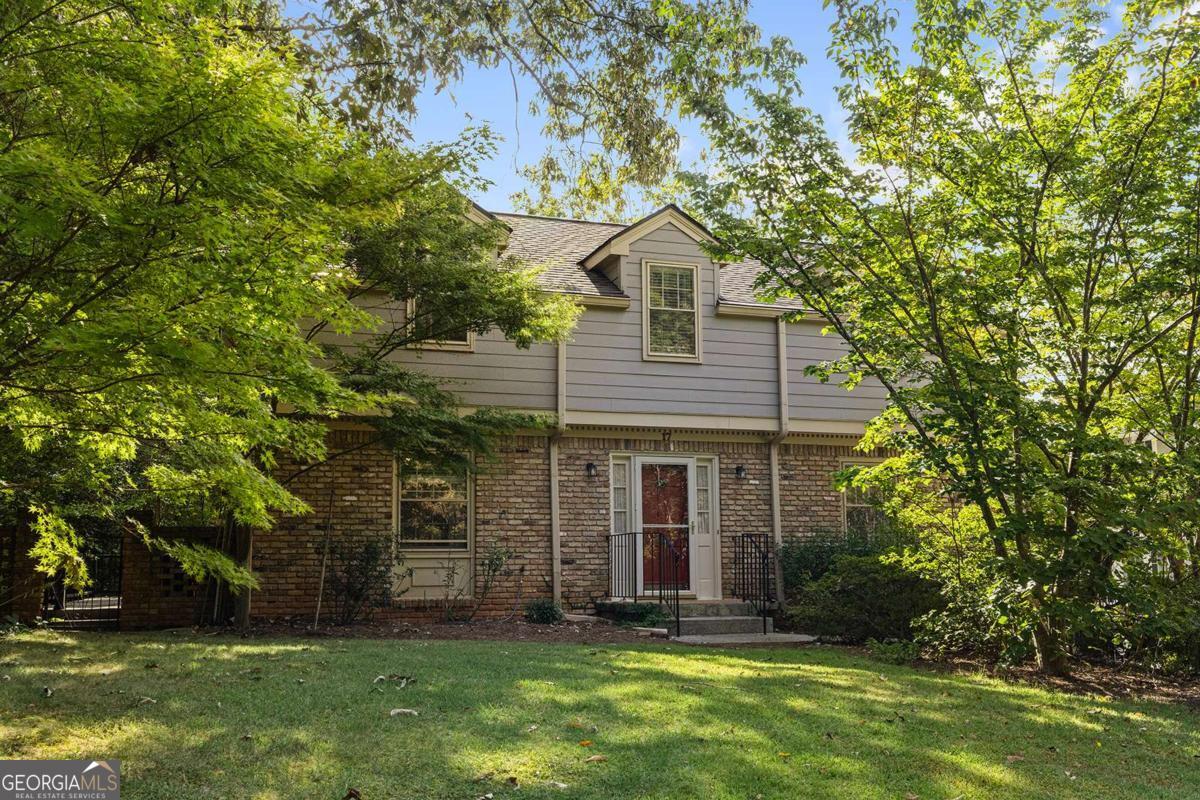 Here's your chance to create something special on one of Avondale Estates' most desirable streets. 17 Kensington Road is a 4-bedroom, 3-bath brick traditional with great bones, a generous floorplan, and the kind of potential buyers are looking for in today's market. Well cared for over the years, this home is ready for a fresh vision; update the kitchen and baths, bring your style, and make it completely your own. Inside, you'll find bright and spacious living and dining rooms, a cozy den with a fireplace and built-ins, and a main-level bedroom and bath for guests or office space. Upstairs offers a large primary suite and two additional bedrooms, all with hardwood floors. The drive-under garage adds extra storage and plenty of space for hobbies, projects, or the classic basement workshop setup. Outside, the side deck provides a peaceful spot to enjoy your morning coffee, grill with friends, or take in the tree canopy over the deep, shaded lot that backs up to one of Avondale's beloved neighborhood commons. Avondale Estates is a true community with walkable streets, parks, and restaurants nearby. Plus, the city is actively redeveloping its retail corridor, adding more dining, shopping, and gathering spots-making now the ideal time to invest here. In a tight real estate market, homes on Kensington Road don't come up often. Bring your contractor, your Pinterest boards, and your imagination, and turn this well-maintained home into the one you've been dreaming about.