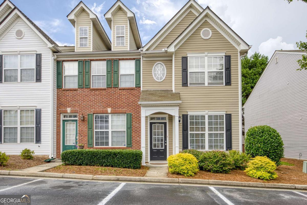 Welcome to this charming end-unit townhome featuring two private en-suites in a swim and fitness community. Perfectly located near reputable schools, just minutes from I-85, and close to healthcare, shopping, dining, and entertainment, including Sugarloaf Mills. Outdoor enthusiasts will love being near Collins Hill Park, Suwanee Creek, and Peachtree Ridge Park with miles of scenic trails and recreational opportunities. Enjoy a covered front entry that leads into a tiled foyer and a flexible dining room that could easily serve as a home office. Peninsula-style kitchen, complete with a breakfast bar, stainless steel appliances, and generous counter space for meal prep and entertaining with an effortless flow into the family room featuring a cozy wood-burning fireplace. Upstairs, the vaulted primary suite has been thoughtfully updated with new ceramic tile, a walk-in shower, and a free-standing soaking tub, creating a spa-like retreat at your fingertips. A second en-suite bedroom provides flexibility and privacy for guests or roommates. Step outside to a private deck with wooded views, ideal for relaxing, grilling, or dining under the stars. A convenient outdoor storage room offers space for your grill, tools, and seasonal decor. Water, trash, fitness center, and pool access are all included, offering both value and convenience in this well-maintained community.