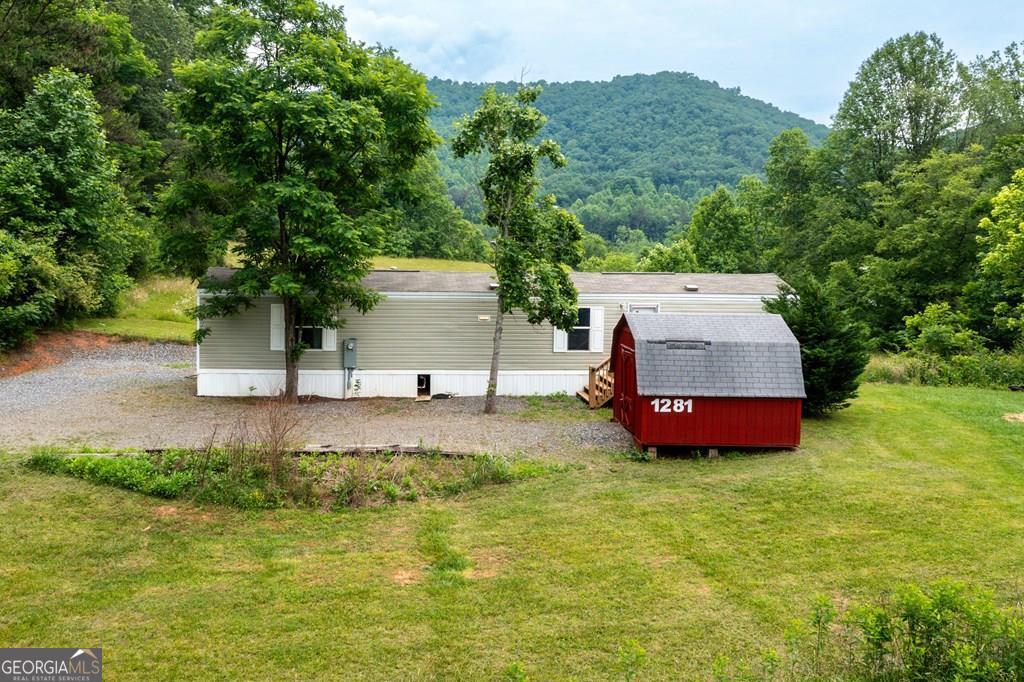 Immaculate Manufactured Home Overlooking Beautiful Pasture & mountains in North Carolina! Experience tranquil living in this immaculate 2-bedroom, 2-bathroom furnished manufactured home nestled in the picturesque mountains of North Carolina. Perfectly positioned to overlook stunning pastures & mountains, this home offers both comfort and convenience. Key Features: Open Floor Plan: The living room seamlessly flows into an eat-in kitchen, creating a welcoming space for gatherings and daily living. Spacious Covered Back Deck: Perfect for enjoying the breathtaking mountain and valley views year-round. Extra Storage: Includes a separate storage building to accommodate all your needs. Ample Parking: Plenty of parking space for you and your guests. No Deed Restrictions: Offering you the freedom to make this property truly your own. Prime Location: Just minutes from the charming downtown area of Hayesville, providing easy access to local amenities and attractions. This property combines serene mountain living with modern comforts, making it an ideal retreat for those seeking peace and privacy.
