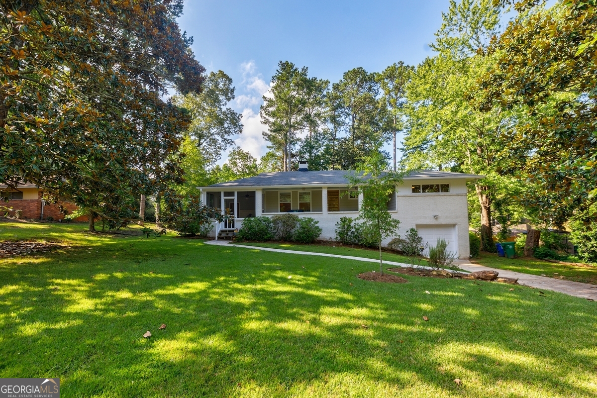 This home is not an investor flip. This home was lived-in and loved-on -- and it shows! The original hardwood floors throughout this 3 bedroom, 2 bathroom mid-century ranch are beautiful. Cooking is a joy in this gorgeous and open white kitchen with glass tile backsplash and high-end low-decibel dishwasher, flooded with natural light and adorned with gleaming light fixtures for cozy evening illumination. Enjoy the outdoors on your back patio conveniently off the kitchen for outside cooking and dining and overlooking a large private grassy backyard filled with flowering trees and shrubs. Backyard is fully-fenced and secure for small dogs. Entertain in your large fully-screened side porch with tropical ceiling fan off the other side of your kitchen. Large master has a new en-suite bath with whisper quiet ventilation fan. Wood-burning corner fireplace and custom blinds in living room. Relax in the evenings on your deep, full-length front porch and gaze across your delightful front yard with newly planted trees into the night sky. The HVAC ducts were reconfigured 4 yrs ago for optimal air flow as was blown-in attic insulation and an attic fan, and together with newer windows (that are a breeze to open, close and clean) this home stays comfortable all year long. Full, daylight basement is dry as a bone and ready for you to finish for additional living space or rental unit. Seller is a licensed Georgia real estate agent.