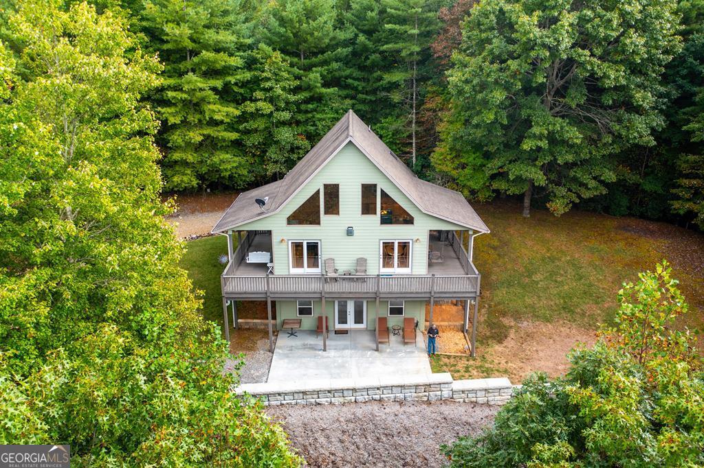 Rustic Mountain Retreat in the Heart of North Carolina Discover the serenity of the Nantahala National Forest w/ this stunning 2-bedroom, 3-bathroom rustic retreat, enveloped in natural beauty & privacy. This property offers a blend of seclusion & accessibility, making it an ideal getaway or permanent residence for those seeking a harmonious lifestyle amidst nature. Key Features & Amenities: Expansive Outdoor Living: Enjoy breathtaking mountain views from the full-length wrap-around deck & covered porch. These spaces provide an ideal setting for relaxation or entertaining guests, offering both up-close & long-range vistas of the serene landscape. Charming Exterior: Built w/ attention to detail, the house features a Hardie Board exterior adorned w/ rock accents, seamlessly integrating w/ its natural surroundings. Warm Interiors: The great room is highlighted by a cathedral ceiling & a stacked block gas log fireplace, creating a cozy & inviting atmosphere. The mix of tongue-and-groove wood & drywall, alongside varied flooring including hardwood, tile, & carpet, adds elegance & comfort. Spectacular Windows: A beautiful glass front ensures the interior is bathed in natural light, maximizing the stunning views & fostering a bright, airy environment. Functional Spaces: The property includes a spacious laundry room, generous closet space, a versatile loft, & ample storage, ensuring all your practical needs are met. Finished Basement: Designed for entertainment, the basement boasts a full TV area, a bar, & a game area, offering a perfect backdrop for gatherings & creating lasting memories. This property is perfectly suited for those seeking a peaceful retreat in the NC mountains. Unique points include its expansive outdoor living areas, distinctive charming exterior, and exquisite interior design sets it apart .