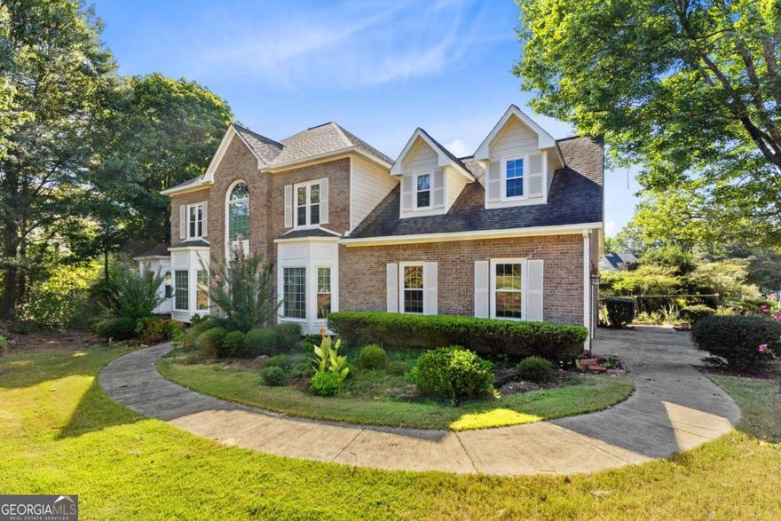 Welcome to this stunning three-sided brick home in East Cobb! Thoughtfully updated with new siding, energy-efficient windows, and  professionally installed leaf gutters, this residence blends classic charm with modern comfort. The spacious main-level primary suite boasts  a tray ceiling and a luxurious bath, while the open-concept kitchen flows seamlessly into the family room and sunroom-perfect for  everyday living and entertaining. Hardwood floors highlight the main living areas, complemented by newly installed carpet in select spaces.  Upstairs, generous bedrooms provide comfort and versatility for the whole family. The daylight basement, partially finished with a  workshop, adds even more flexibility for work, play, or hobbies-all set on a beautifully landscaped lot. Situated in the highly sought-after  Lassiter High School district, ranked among the best in Georgia, this home is nestled within a safe, family-friendly community just 20 miles  from downtown Atlanta. Residents enjoy easy access to The Avenue East Cobb for shopping and dining, local parks for recreation, and  major grocery stores just minutes away.