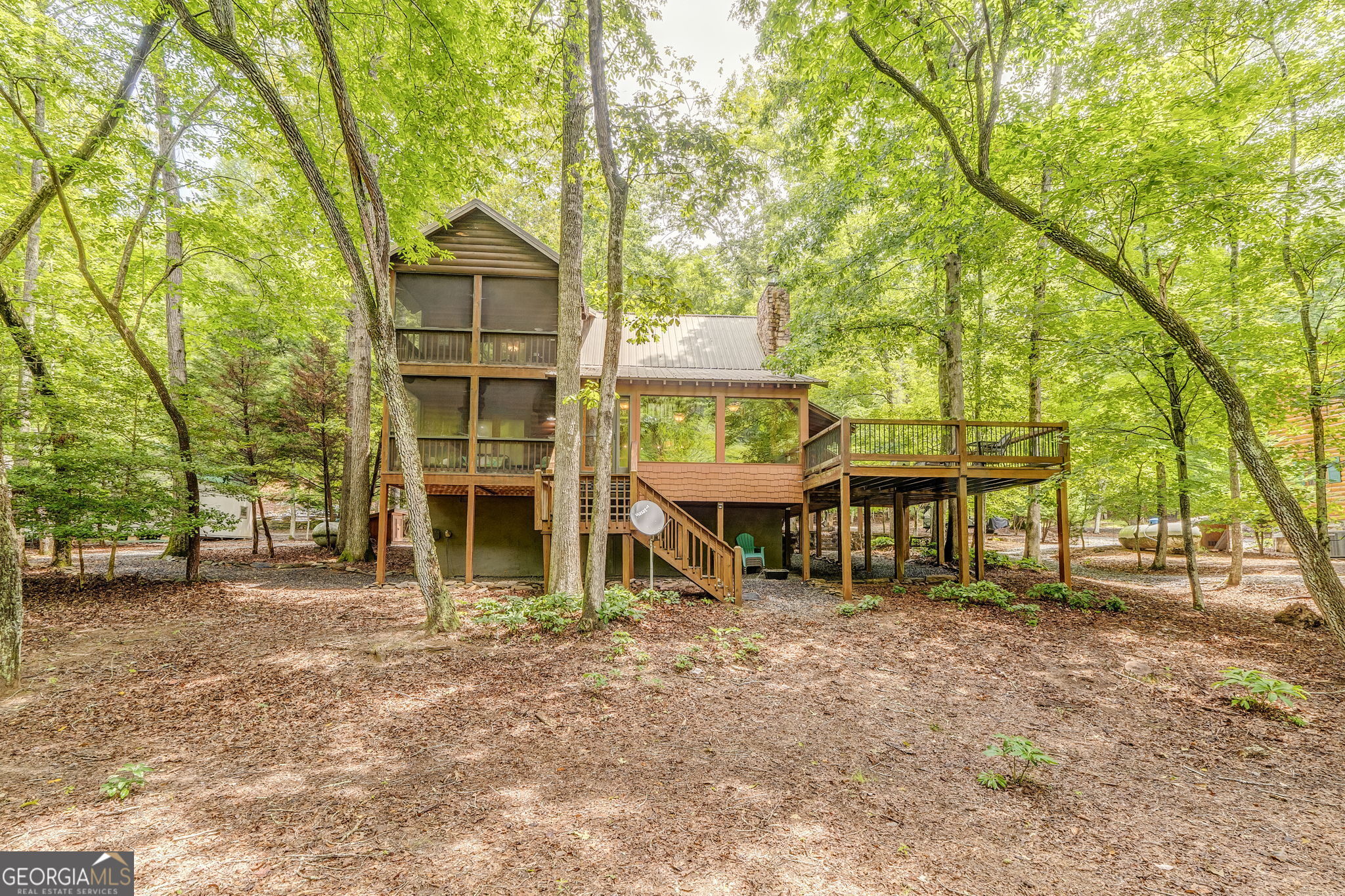 WELCOME TO YOUR RUSTIC RIVERFRONT RETREAT IN THE GATED COOSAWATTEE RIVER COMMUNITY IN ELLIJAY, GEORGIA! Escape to the foothills of the Appalachian Mountains to a charming log cabin nestled on 0.75 acres. The Gilmer County property is just a short drive from Atlanta and Chattanooga. Offering the perfect blend of peace, comfort, and adventure, this 1,464 square foot cabin offers two bedrooms and two bathrooms. Each bedroom features its own private screened porch, ideal for sipping coffee and soaking in the sounds of nature. The open-concept living room, complete with a gas fireplace, flows into a full kitchen with granite countertops, a center island, and plenty of space for gatheringOutside, you'll find three porches, a deck, and a two-car carport, along with a spacious, level yard that's great for relaxing or entertaining. The property borders the Coosawattee River, offering direct access for floating, trout fishing, and enjoying the soothing sounds of the water. Community amenities are available for your enjoyment, including a swimming pool, campground, hiking trails, and well-maintained roads. Whether you're looking for a full-time home, a weekend retreat, or a proven rental investment, this riverfront cabin is the perfect place to unplug and unwind.