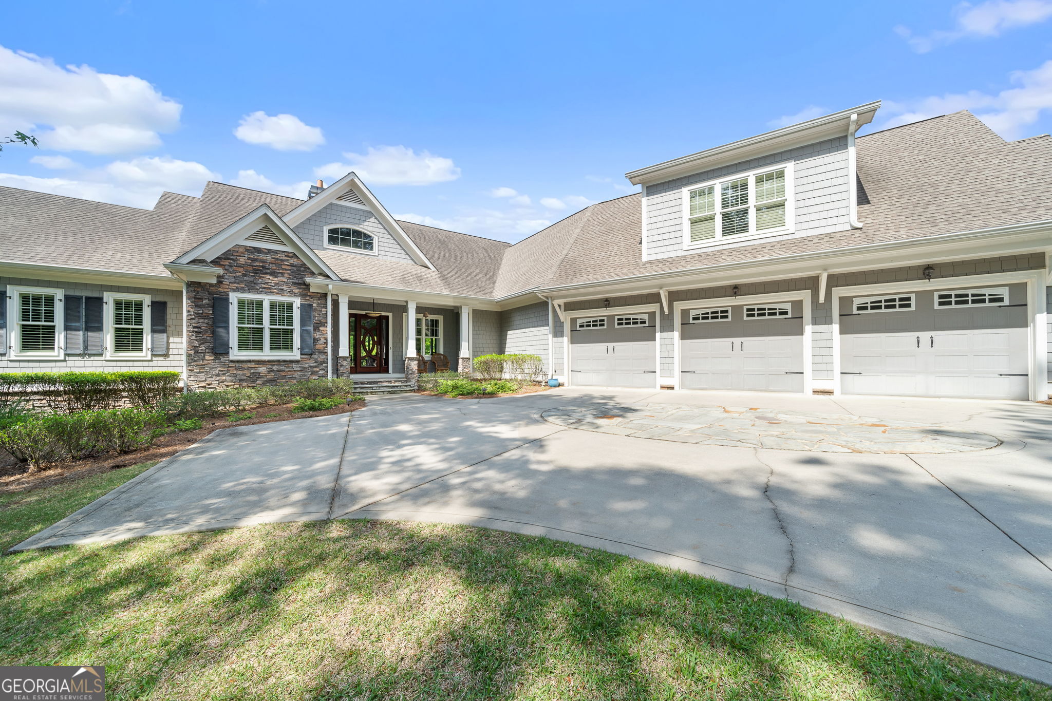 Experience the pinnacle of lakefront luxury with this custom-built masterpiece, perfectly positioned along nearly 185 feet of the coveted Richland Creek shoreline on Lake Oconee. Enjoy sweeping views of the tranquil waters and Harbor Club's #5 green and #6 tee, blending the peacefulness of lake life with the prestige of golf course vistas. Originally built in 2008 and beautifully remodeled in 2013, this stone-and-shake estate radiates timeless elegance. Step through the striking front door into a stunning open-concept layout designed to impress. The main level, recently refreshed with designer-selected neutral tones, features a vaulted great room with painted beams and abundant natural light. The chef's kitchen boasts custom solid maple shaker-style cabinetry and a double island, ideal for entertaining or cozy family gatherings. Two spacious dining areas provide flexibility for any occasion. The main level offers both the luxurious primary suite and an additional bedroom suite for ultimate convenience and privacy. Above the three-car garage, a private guest suite welcomes visitors or extended family. Downstairs, the terrace level is a true retreat, complete with a large recreation room, fully equipped bar, and two additional bedrooms and baths-each with breathtaking views. The thoughtfully designed laundry room and pantry deliver exceptional functionality and storage. Outdoor living is unmatched here: relax on the expansive screened porch, soak up the sun, or entertain at the water's edge on the "cool-on-feet" vinyl dock, equipped with a boat lift and dual jet ski lifts. NOTE: 8' of water depth at dock, and new dock cover. This exceptional property offers the ultimate combination of luxurious comfort, spectacular views, and outdoor recreation-truly the best of all worlds. Lakefront opportunities like this in Harbor Club are rare. Your dream lakefront lifestyle awaits!