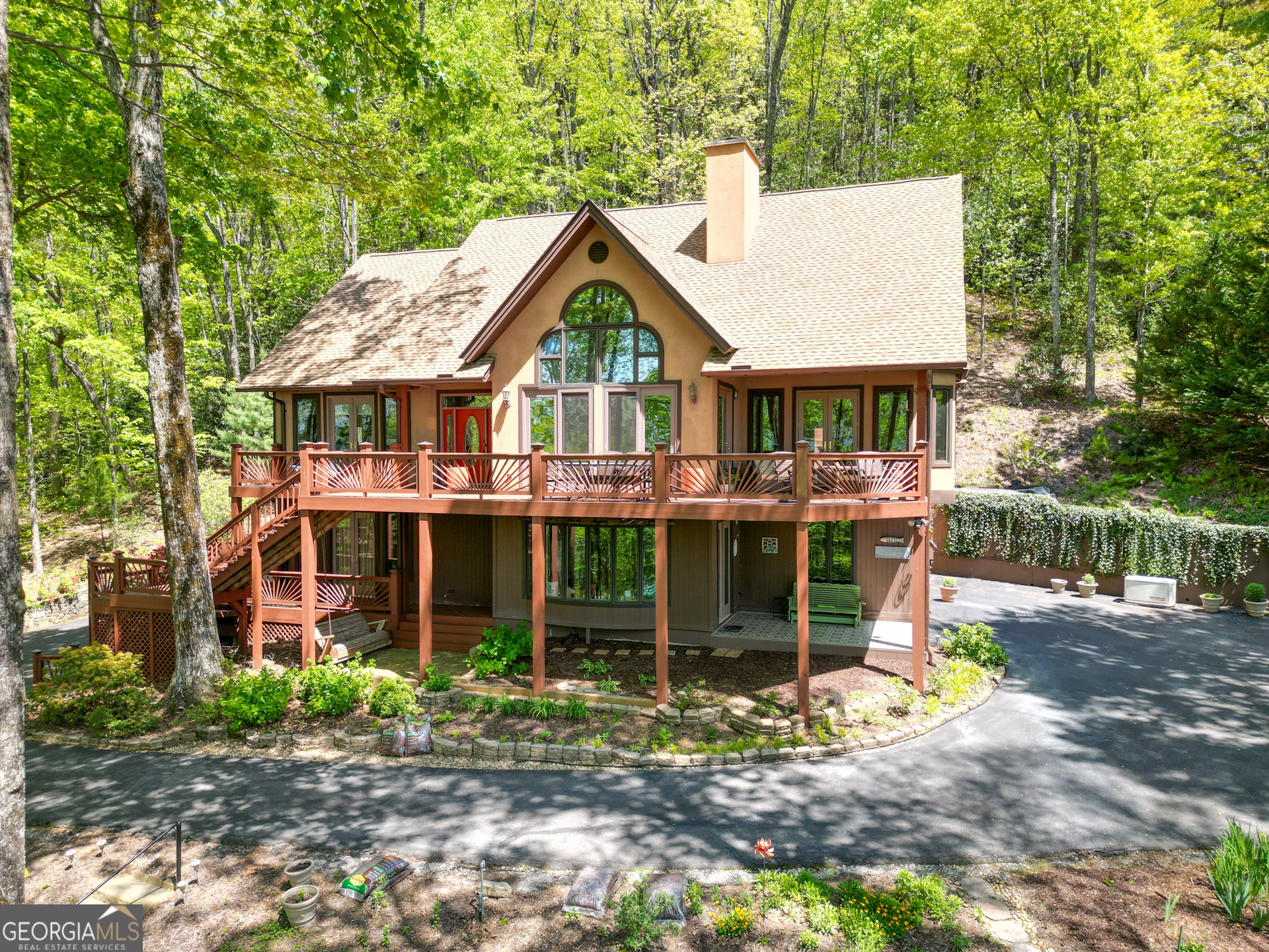 Your Mountain Sanctuary Awaits! Perched majestically in the beautiful North Georgia Mountains, this spectacular home offers an extraordinary connection to Lake Burton. Wake up to breathtaking, year-round views of the main body of Lake Burton, complemented by expansive winter mountain vistas. This is more than a home; it's a lifestyle defined by natural beauty, serene moments, and a vibrant lake and mountain community. Built with enduring steel frame construction, this 3 bedroom, 3.5 bath residence promises lasting quality and peace of mind. The heart of the home is its custom 'gathering' kitchen, a true culinary command center featuring a large island, generous pantry with pull-outs, a convenient prep sink, and exquisite granite countertops. It's fully equipped with separate Sub-Zero refrigerator and freezer units, ensuring every culinary need is met. Adjacent to this hub, the large dining room comfortably seats 10+, perfect for hosting memorable gatherings. The open living spaces are anchored by a magnificent stone 3-sided fireplace with gas logs, creating a warm ambiance. Throughout the main level, you'll find elegant oak hardwood floors and updated light fixtures. All bedrooms boast numerous built-in cabinetry, offering both style and practical storage. The main level also features a dedicated home office area, perfect for remote work or quiet study. Step outside to embrace the stunning surroundings from spacious upper and lower decks, ideal for enjoying the panoramic views and unforgettable sunsets. Two additional covered porches provide intimate spots for relaxation. This meticulously maintained home features a recently new 40-year Architectural shingle roof and is well insulated for low utility costs. For ultimate peace of mind, a Generac generator ensures continuous comfort. Practical amenities include a side-entry double garage with ample storage and abundant outdoor parking. The lower level offers a versatile game day, man cave, or den, providing ample space for entertainment and relaxation. Nestled within Charlie Mountain Retreat, a private community known for its welcoming atmosphere and well-maintained roads, you'll enjoy a sense of belonging with great neighbors. High-speed internet is available via TruVista (ISP), keeping you connected. Experience the best of mountain and lake living, where every detail contributes to an exceptional lifestyle. Home warranty included - through America's Preferred Home Warranty. Photos of the steel construction are included at the end of the photos.