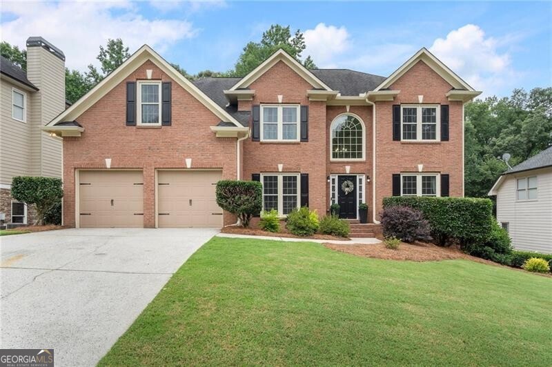 Welcome to this beautifully updated brick-front home offering a perfect blend of comfort, style, and functionality. Step into a grand two-story foyer with hardwood floors that flow through the dining room, office, kitchen, and breakfast area. The open floor plan is enhanced by abundant natural light, an elegant archway, a gas fireplace, and dramatic floor-to-ceiling windows in the great room. The kitchen is a chef's dream, featuring white cabinetry, granite countertops, a gas cooktop, walk-in pantry, and a large island with bar seating. A main-level bedroom offers flexibility, while the dedicated office is framed by French doors and includes built-in cabinets, shelving, and a desk. The FRESHLY PAINTED interior showcases wainscoting in the dining room, newer light fixtures throughout, and a spacious laundry room with a custom folding table. Upstairs, the oversized primary suite boasts tray ceilings, a sitting room, and newer luxurious HIS AND HERS WALK IN CLOSETS. The REMODLED ENSUITE primary bathroom features dual vanities, garden tub, updated shower and stylish tile flooring. Secondary bedrooms share an updated Jack-and-Jill bathroom with tile floors, newer shower/tub, private vanities and a makeup station. The daylight basement is stubbed for a bathroom and offers ample room for an exercise space, workshop, or future expansion. Outside, enjoy a newer wooden fenced yard with lush landscaping, hammocks, a newer deck, and a newer paved patio/walkway. Additional upgrades include a wine bar with a wine fridge, NEWER WINDOWS, NEWER EXTERIOR DOORS, NEWER HVAC'S, and a newer LeafGuard gutter system. Located in a vibrant community with resort-style amenities including a clubhouse, fitness center, golf, pickleball, tennis, playground, lake, sidewalks, restaurant, pool with swim team, and more-just minutes from top-rated schools, shopping, and dining.