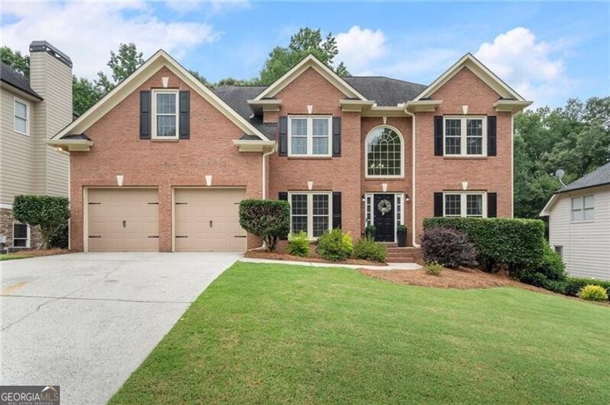 Welcome to this beautifully updated brick-front home offering a perfect blend of comfort, style, and functionality. Step into a grand two-story foyer with hardwood floors that flow through the dining room, office, kitchen, and breakfast area. The open floor plan is enhanced by abundant natural light, an elegant archway, a gas fireplace, and dramatic floor-to-ceiling windows in the great room. The kitchen is a chef's dream, featuring white cabinetry, granite countertops, a gas cooktop, walk-in pantry, and a large island with bar seating. A main-level bedroom offers flexibility, while the dedicated office is framed by French doors and includes built-in cabinets, shelving, and a desk. The FRESHLY PAINTED interior showcases wainscoting in the dining room, newer light fixtures throughout, and a spacious laundry room with a custom folding table. Upstairs, the oversized primary suite boasts tray ceilings, a sitting room, and newer luxurious HIS AND HERS WALK IN CLOSETS.  The REMODLED ENSUITE primary bathroom features dual vanities, garden tub, updated shower and stylish tile flooring. Secondary bedrooms share an updated Jack-and-Jill bathroom with tile floors, newer shower/tub, private vanities and a makeup station. The daylight basement is stubbed for a bathroom and offers ample room for an exercise space, workshop, or future expansion. Outside, enjoy a newer wooden fenced yard with lush landscaping, hammocks, a newer deck, and a newer paved patio/walkway. Additional upgrades include a wine bar with a wine fridge, NEWER WINDOWS, NEWER EXTERIOR DOORS, NEWER HVAC'S, and a newer LeafGuard gutter system. Located in a vibrant community with resort-style amenities including a clubhouse, fitness center, golf, pickleball, tennis, playground, lake, sidewalks, restaurant, pool with swim team, and more-just minutes from top-rated schools, shopping, and dining.