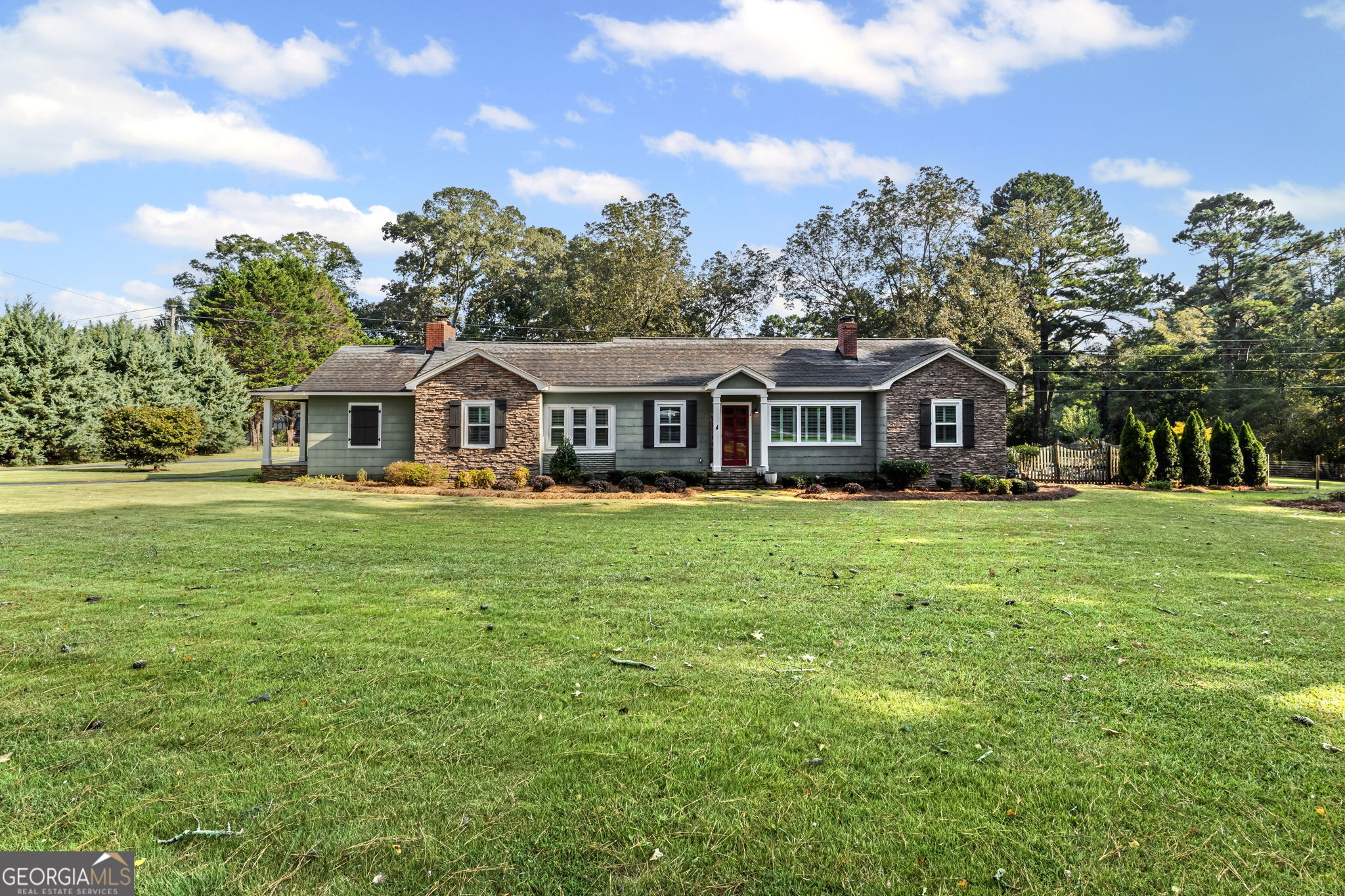 BEAUTIFUL FARMHOUSE WITH A POOL ON A SPACIOUS AND PRIVATE TWO-ACRE LOT. Gorgeous hardwood floors, plantation shutters, updated kitchen with marble countertops, new appliances and fixtures, beautiful cabinets, large island, coffee nook, living room with brick fireplace, built-in bookshelves, separate dining room with built-in china cabinet, glass transoms, beadboard ceilings, big den w/ lovely natural light, powder room with laundry in hall. Roomy master bedroom with brick, wood-burning fireplace, exposed beams, fantastic master bath with walk-in tiled shower, soaking tub, walk-in closet with built-ins, private entrance to wrap around porch. Split bedroom plan with nice-sized bedrooms. Screened porch off back foyer entrance. Backyard oasis with back deck with pergola, 16 x 32 pool, outdoor kitchen, pool house, speakers, outdoor shower, fire pit area, waterfall, fenced backyard, chicken coops, kennel, workshop, with power (240 amp), barn with stables, storage space, ample parking for RV. Enjoy life in the country while being close enough to downtown Newnan, Ashley Park and I-85.