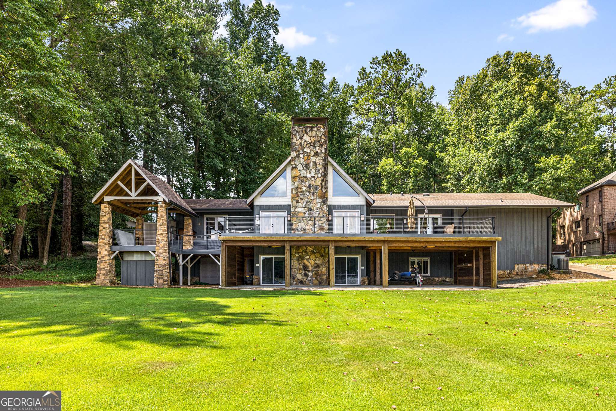 Discover the perfect blend of relaxation and recreation in this stunning 3- bed, 3.5-bath lakefront retreat on the private waters of Lake Spivey! For a limited time you can purchase this home with a 1 point, 1 year rate buy down, at no additional cost. Contact us so we may connect you with our preferred lender for this great offer! Thoughtfully designed for everyday comfort and effortless entertaining, this home features a home theater, private gym, sauna, and year-round lake views. Inside, soaring ceilings and a grand stone fireplace define the great room, while the modern eat-in kitchen sets the stage for culinary creations. The open loft offers a versatile space for a home office, library, or cozy retreat. The primary suite is a true escape with vaulted ceilings, skylights, French doors to the deck, a custom vanity, spa-like bath and steam shower, and spacious walk-in closet. Two generous secondary bedrooms are connected by a Jack-and-Jill bath-perfect for family or guests. Step outside to your expansive balcony, perfect for dining al fresco. Downstairs you will find another expansive entertainment space complete with a wet bar, home theater, gym and patio with motorized electric screens. A short walk and you will be on your own private dock with 2 motorized boat lifts. Indulge in a sunset boat cruise, kayaking or paddleboarding. And did we mention there is no public access to the lake making the outdoor spaces your private sanctuary! There is also an additional stone patio overlooking the lake. Add a fire pit and adirondack chairs for the perfect evening lounging space. The home comes with a whole home speaker system, water purification system in the kitchen and smart irrigation. Enjoy community favorites like the Lake Spivey Shoot Out in the spring and spectacular 4th of July fireworks along with close proximity to attractions such as the International Park (Spivey Splash Park). With no HOA (just a low annual lake association fee), this home offers the ultimate in relaxed, lakeside luxury.