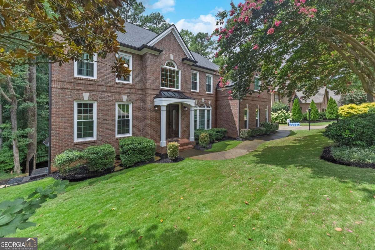 Stunning 5-Bedroom Home in Towne Lake Hills North - Swim/Tennis/Golf Community. Welcome to this elegant 5-bedroom, 5-bath home boasting 4,783 sq ft of beautifully designed living space in the highly sought-after Towne Lake Hills North community. Perfectly positioned in a neighborhood offering resort-style amenities-including swimming, tennis, and golf-this home blends everyday comfort with timeless style. Step inside to find a spacious primary suite featuring two walk-in closets and a spa-like bath. A guest bedroom with full bath on the main level provides convenience and privacy for visitors. The heart of the home is the keeping room with cozy fireplace, seamlessly connected to the kitchen with white cabinetry, stone countertops, and ample workspace. The finished basement is an entertainer's dream, complete with a stone fireplace, full bar, and theater room-perfect for movie nights or hosting gatherings. Outdoor living shines with double decks and a covered screened area, ideal for year-round relaxation. Recent upgrades including new windows, HVAC, and roof add peace of mind and energy efficiency, making this home truly move-in ready. Call to learn more about possible 3% VA assumable mortgage.