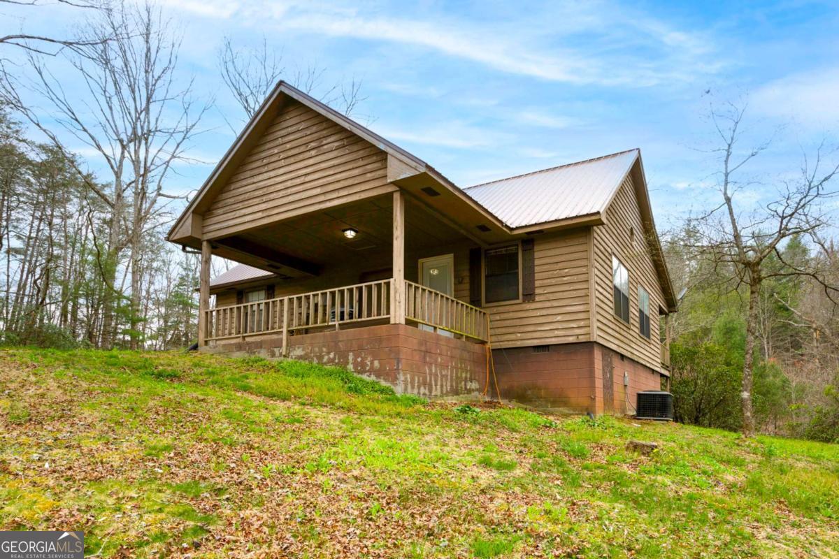 THIS QUAINT MOUNTAIN HOME IS SITUATED ON RICHARD RUSSELL SCENIC HIGHWAY. 2 BR/2BA OPEN CONCEPT. DRINK COFFEE ON THIS HUGE FRONT PORCH WITH LOTS OF TREE COVERAGE. QUIET WITH LOTS OF WILDLIFE 5-10 MINUTES OUT OF BLAIRSVILLE. MINUTES TO VOGEL STATE PARK. outdoor storage building will remain with property.
