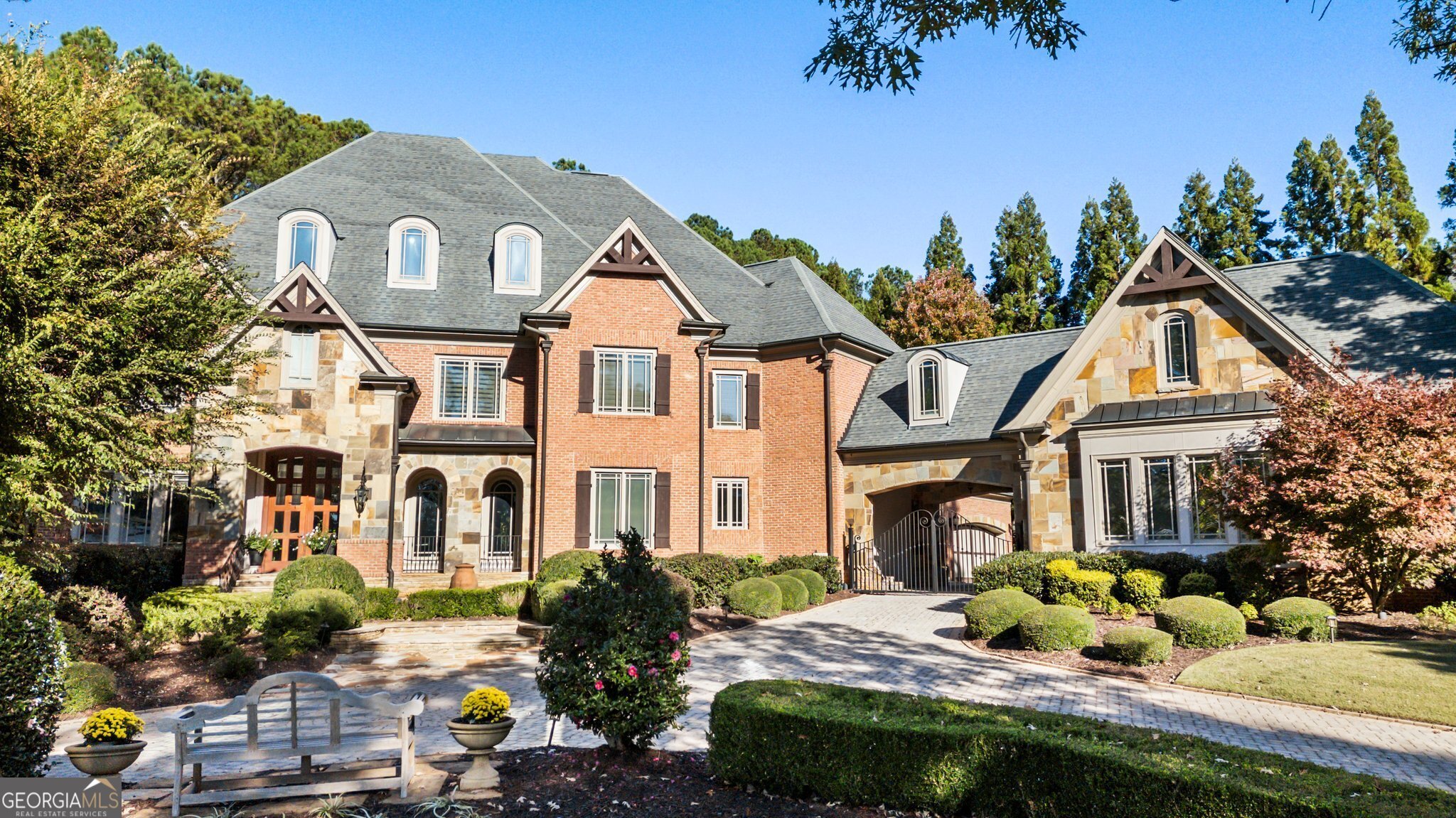 This home sets the new standard of exquisite in North Atlanta. Finally sophisticated design meets modern functionality and breathtaking outdoor living. Located in the most exclusive and private community in Windward... The Peninsula at Northshore... a double gated private street by the lake and by the golf course. This home has been renovated throughout and truly is a work of art. Feel like you are always on vacation while enjoying the gorgeous pool with infinity edge spa, water features, extensive lanai, full kitchen and pool house featuring a full bath. Situated on 1.46 flat acres, enjoy sweeping views of the Golf Club of Georgia, relax or play in the dreamy meadow with hammocks and flat useable park-like topography. Once inside, experience a level of custom luxury and masterful craftsmanship you can only imagine. Every room in the home boasts fabulous features such stunning ceilings, luscious lighting, beautiful wood beams and intricate, very custom design. An unforgettable front door and two-story grand entry opens to the elegant, curved staircase and an elegant welcome into the home. The kitchen is an absolute masterpiece. Completely remodeled, you truly must see if for yourself to appreciate all of the thought, high end finishes and materials as well as workmanship that went into their construction. The 13-foot quartz island is a showstopper with double sink, two faucets, quartz footrests, all high end appliances under counter. But not to be outdone, the Blue Star range will impress even the professional chef. All appliances are top of the line. All of the cabinets are ultra soft close. You will love the scullery with all new appliances, counters, backsplash and mudroom addition. Just steps away, custom cabinets, heavy beams and massive fireplace define the family room open to the kitchen. All bedrooms are ensuite, and all have towel warmers and unparalleled finishes. The choice of three primary suites awaits....one on every floor with an elevator to take you there with ease. The primary suite is a relaxing retreat beyond measure. Enjoy the sunny curved sitting room with coffee bar. Oversized with a fireplace and beautiful ceiling, you will want to go to bed early and sleep late. Three additional bedrooms shine on the second floor. Fall in love with the Ctrain bedroomC with a working train that meanders from the bedroom to the attached media room and back again. The terrace level is the continuation of divine with full kitchen, billiards room, state of the art theatre room, full bedroom/bath, gym and new outside courtyard. For extra privacy, the home offers an automatic gate to the parking area and two garages with a total of 5 garage spaces. The presence this home has from the street is unmatched in North Atlanta with its cobblestone circular drive and the beautiful mix of stone and brick. Experience this home with a private tour. It's life changing and ready for you.