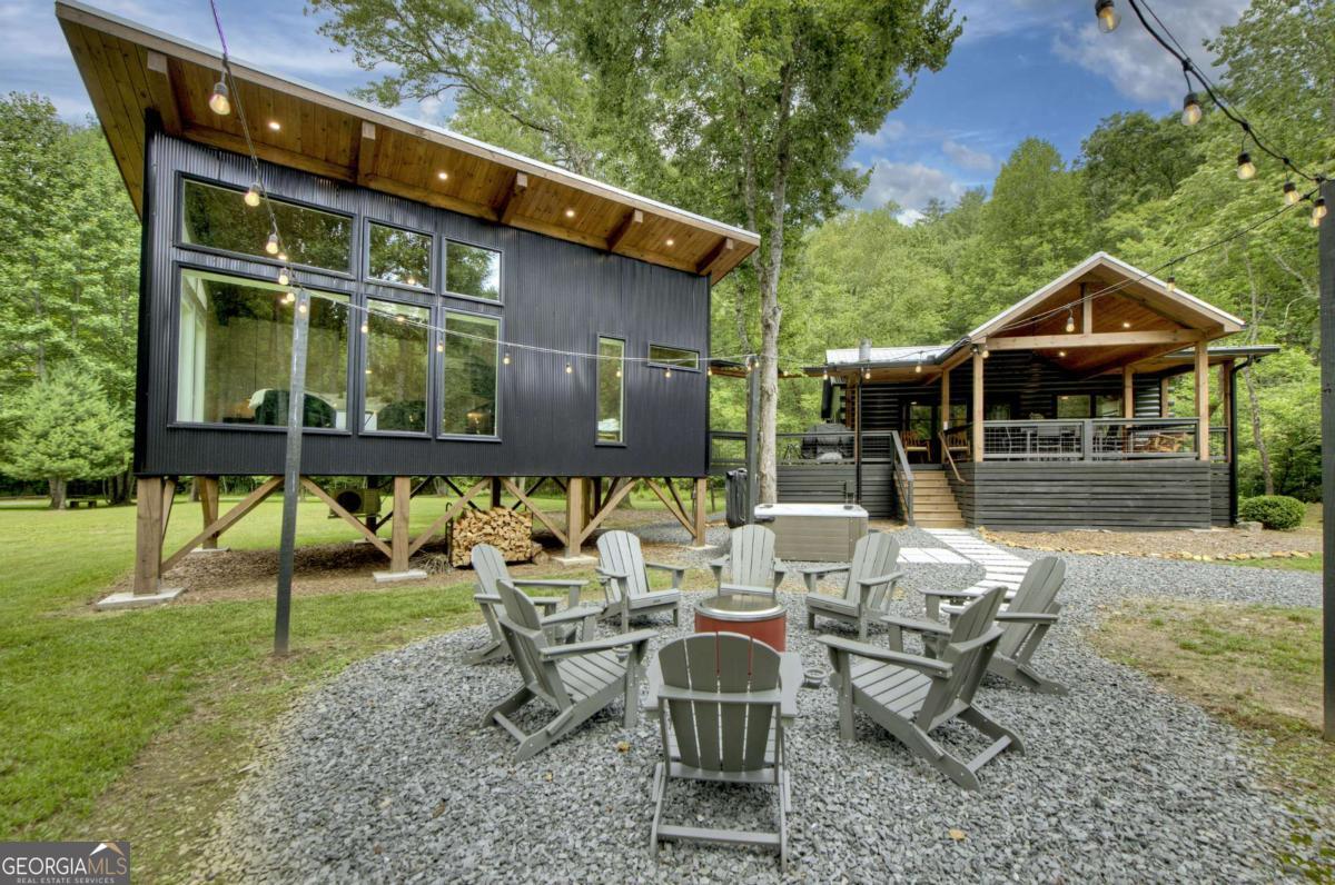 Welcome to "Fish Camp" - a one-of-a-kind creekfront retreat nestled on 3.4 acres spanning three lots along the banks of Fightingtown Creek, one of the most sought-after trout streams in the Blue Ridge Mountains. This beautifully renovated 3-bedroom, 2-bath cabin offers the perfect blend of rustic charm and modern comfort, with unmatched outdoor amenities for relaxation and recreation. The interior features warm wood finishes, a cozy open-concept living space, and updated gourmet kitchen and bathroom areas designed with both style and function in mind. Each bedroom offers a peaceful place to unwind, and the spacious decks provide stunning views of the rushing creek just steps away. Outside is where Fish Camp truly shines. Enjoy your own private slice of nature with level creek frontage, perfect for casting a line or simply soaking in the serenity. Entertain family and friends at the creekside pavilion or head over to the separate party pavilion equipped with ping pong, corn hole, and space to gather. End your evenings around the firepit under the stars, or relax in the hot tub to the soothing sounds of the creek. With its incredible setting, upgraded interior, and extensive outdoor features, Fish Camp is offered fully furnished and turn-key-ready for you to enjoy as a private getaway or an established vacation rental investment. A rare find on Fightingtown Creek, this is mountain living at its best.