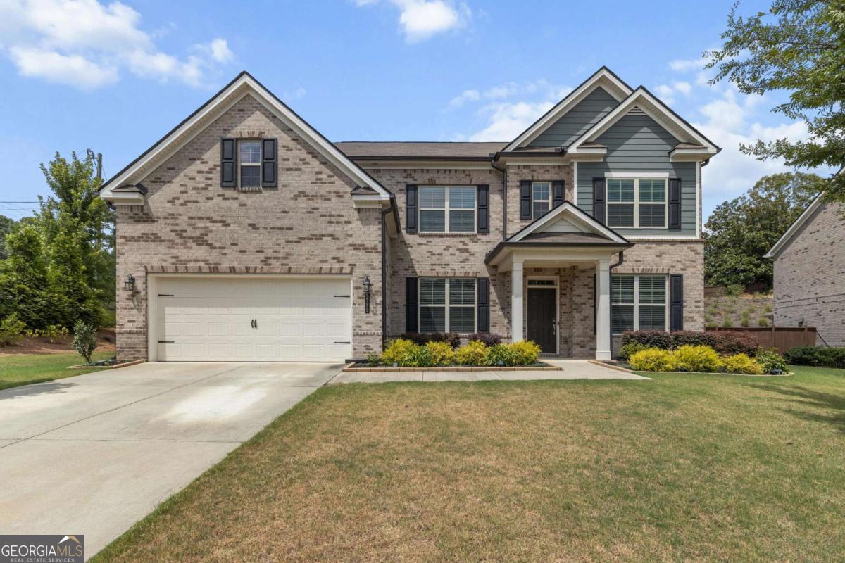 Welcome to this elegant three-sided brick home, ideally located in the highly sought-after North Gwinnett High School district. Situated on a beautifully level front yard with a striking brick facade, this residence offers curb appeal and comfort from the moment you arrive. Step through the front door into a spacious dining room and versatile flex room, perfect for a home office or formal sitting area. The living room features soaring coffered ceilings and a custom built-in bookshelf, creating an inviting space for relaxation and entertainment. The gourmet kitchen is a chef's dream, boasting granite countertops, stainless steel appliances, and a large granite island ideal for gatherings. Enjoy your morning coffee in the bright and airy morning room, overlooking the expansive and private backyard complete with a covered patio, perfect for outdoor dining or weekend barbecues. A convenient guest bedroom with a full bathroom is located on the main floor.Upstairs, the luxurious master suite features a generous walk-in closet, double vanity, soaking tub, and separate shower. Three additional bedrooms and two full bathrooms provide ample space for family and guests. The spacious backyard offers endless possibilities, create your own garden oasis, play area, or future pool. Conveniently located with easy access to Sugar Hill City Center, Suwanee Town Center, Mall of Georgia, and Lake Lanier, this home combines comfort, style, and unbeatable location. Don't miss the opportunity to make this exceptional home yours!