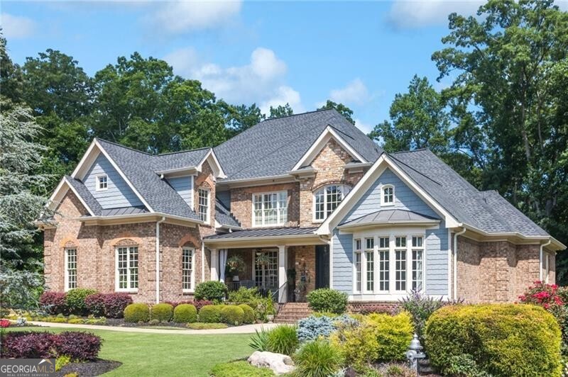 Welcome to 217 Fernwood Place - Luxury Living in Sought-After Fernwood Creek. Nestled just moments from Roswell, East Cobb and Downtown Woodstock but located within Cherokee County for the benefit of lower property taxes, this custom-built six-bedroom, five-and-a-half-bathroom estate is a true masterpiece of design and comfort. From the moment you arrive, the bespoke iron double front doors and soaring two-story foyer set a tone of elegance and sophistication. Inside, a wall of windows in the great room frames your view of the resort-style backyard oasis, inviting natural light and outdoor beauty into your everyday living. The main level offers seamless entertaining with an expansive dining room, two-story great room with custom built-ins and a cozy fireplace, and a chef's kitchen complete with double ovens, gas cooktop, a generous island, and an adjacent keeping room featuring a second fireplace. The main-level primary suite is a retreat unto itself, with vaulted tray ceilings, a private sitting room with fireplace, and direct access to the back deck. The luxury primary bath boasts double vanities, an oversized shower, soaking tub, and a walk-in closet with custom built-ins. Upstairs, you'll find an open loft and three spacious bedrooms, each with their own private en-suite baths - perfect for family or guests. The fully finished terrace level elevates entertainment and functionality with a full bar, stamped copper ceilings, two additional bedrooms, a full bath, exercise room, media room, and a pool table. Walk directly out to your private backyard resort, featuring: Outdoor kitchen with refrigerator and Big Green Egg, Custom heated saltwater Pebble Tec pool by Atlanta Pools and stand alone Pebble Tec Spa, Lush professional landscaping and perennial gardens that bloom year-round. This is more than a home - it's a lifestyle. One visit to 217 Fernwood Place, and you'll never want to leave.