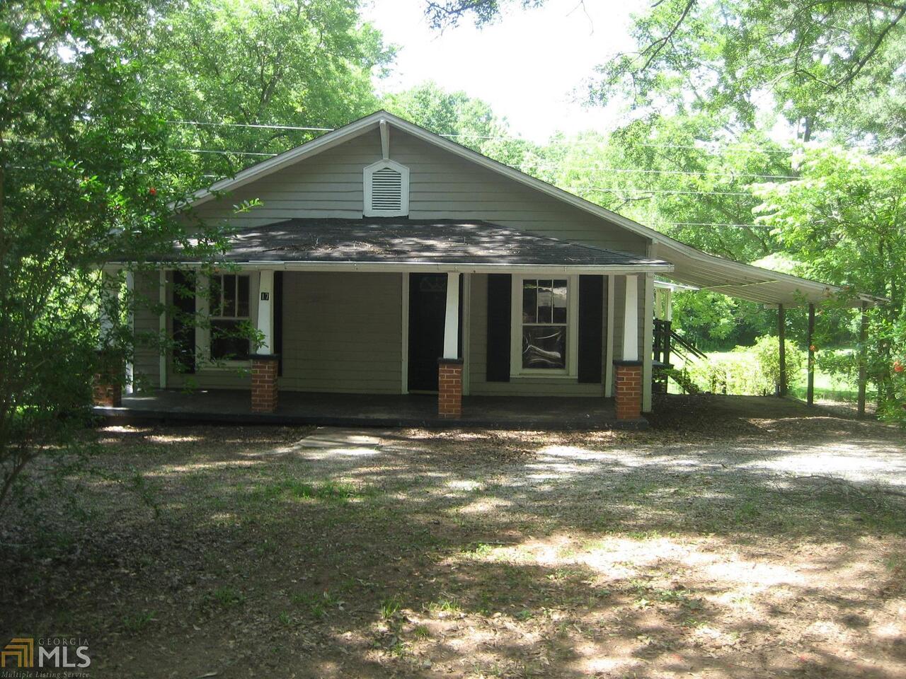 SE Spalding County and within good school districts. 3br/1ba wood siding home built around 1960. .37 acre shady lot. Interior and exterior paint in pretty good shape. Living room with fireplace. Front porch and 1 car parking shed.
