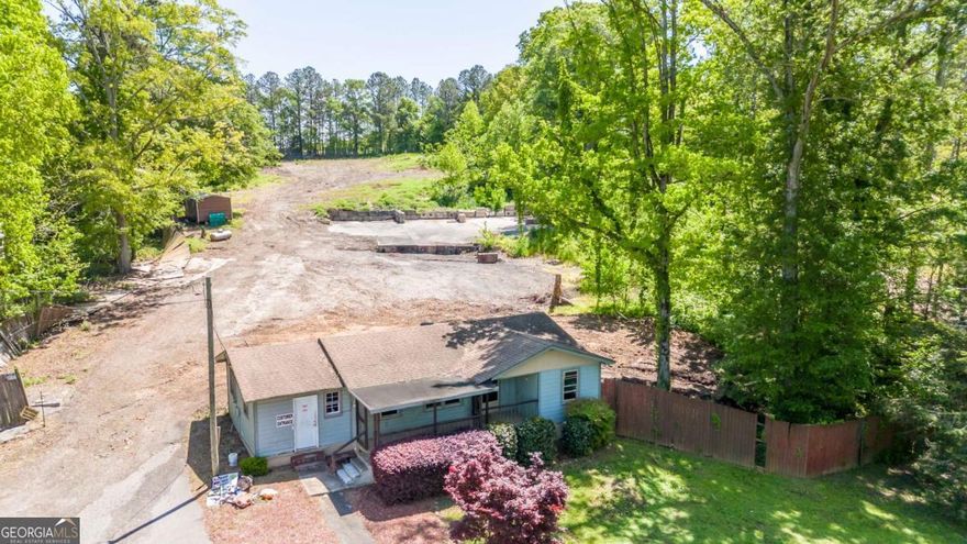 Nearly three acres of prime commercial land on well traveled Hickory Flat Hwy. The previous owner ran a successful landscaping business on the property and there is a small, free standing office building that is just waiting for your renovation or updating. It offers several rooms, a bathroom and storage. There is also an equipment/storage outbuilding but most importantly, acres of flat, cleared, usable land that could accommodate a wide range of businesses and opportunities. Set high above the road, gated, across from a busy shopping/dining plaza with 231 ft of road frontage on Hickory Flat Hwy. Wide variety of potential commercial usage. Unique zoning....GC with Light Industrial usage. Approved for Contractor's Habitat with 8 to 10 potential rental slots for contractors / equipment/ contractor storage. On septic but could connect to sewer at street. Don't miss this unique and lucrative opportunity! Preferred Closing Attorney is Amanda Campbell at Meredith Shearer & Associates in Marietta.