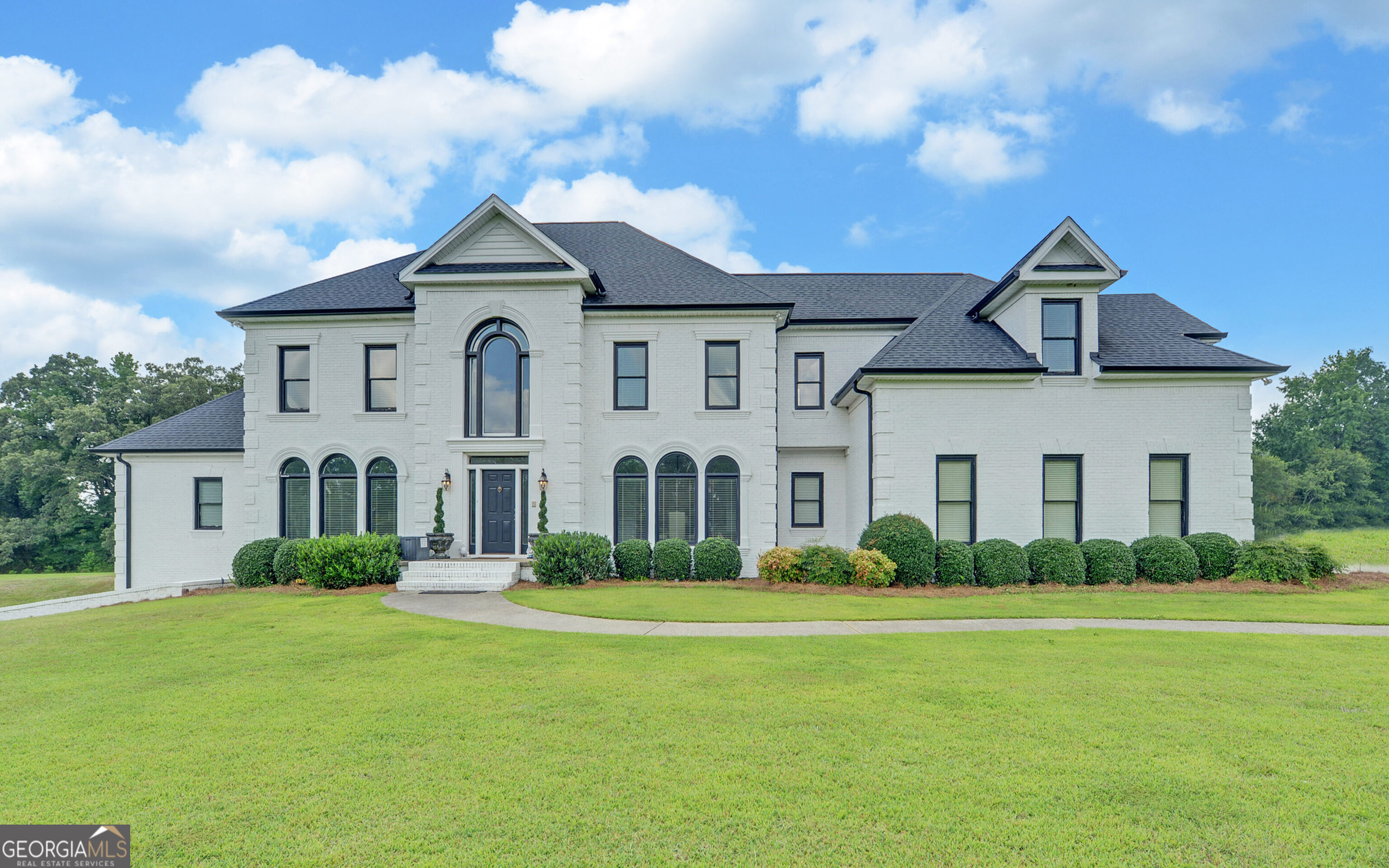 Don't miss this rare opportunity to own a stunning Georgian masterpiece, perfectly blending country charm with city convenience, nestled on 5.14 acres of gently rolling, lush green landscape that exudes serene country charm while remaining centrally located in Buford. This property feels like a serene countryside retreat while being just moments from I-85, conveniently located between Mall of Georgia and Hamilton Mill. The meticulously maintained 5,716 ft2 home features a freshly painted brick exterior, enhancing its timeless elegance. Step inside to soaring ceilings and an open, airy layout with two staircases for seamless access to the main-level laundry. Also, on the main is the master suite offering direct access to a private, Grecian-style oasis featuring a lighted, heated saltwater pool and expansive spa-your personal paradise for relaxation. Nothing has been overlooked. This home boasts four additional oversized bedrooms, each with its own ensuite, plus a versatile living room/office that could serve as a sixth bedroom or second master suite. The gourmet chef's kitchen is a showstopper, equipped with a Sub-Zero refrigerator and perfect for hosting elegant gatherings. Additional features include upgraded flooring, all new pool equipment, new windows and garage doors for enhanced efficiency and curb appeal. Auto enthusiasts will appreciate the extra-wide, extra-deep garage, designed to house classic vehicles. The unfinished basement, with high ceilings and pre-installed plumbing, wiring, and ductwork, is ready for your vision-whether it's a home gym, entertainment hub, or more. Zoned AG-200, this property offers the potential to create a horse farm or a private family compound. This one-of-a-kind property offers unmatched elegance, privacy, and potential. Schedule your private tour today to experience this Southern beauty firsthand!