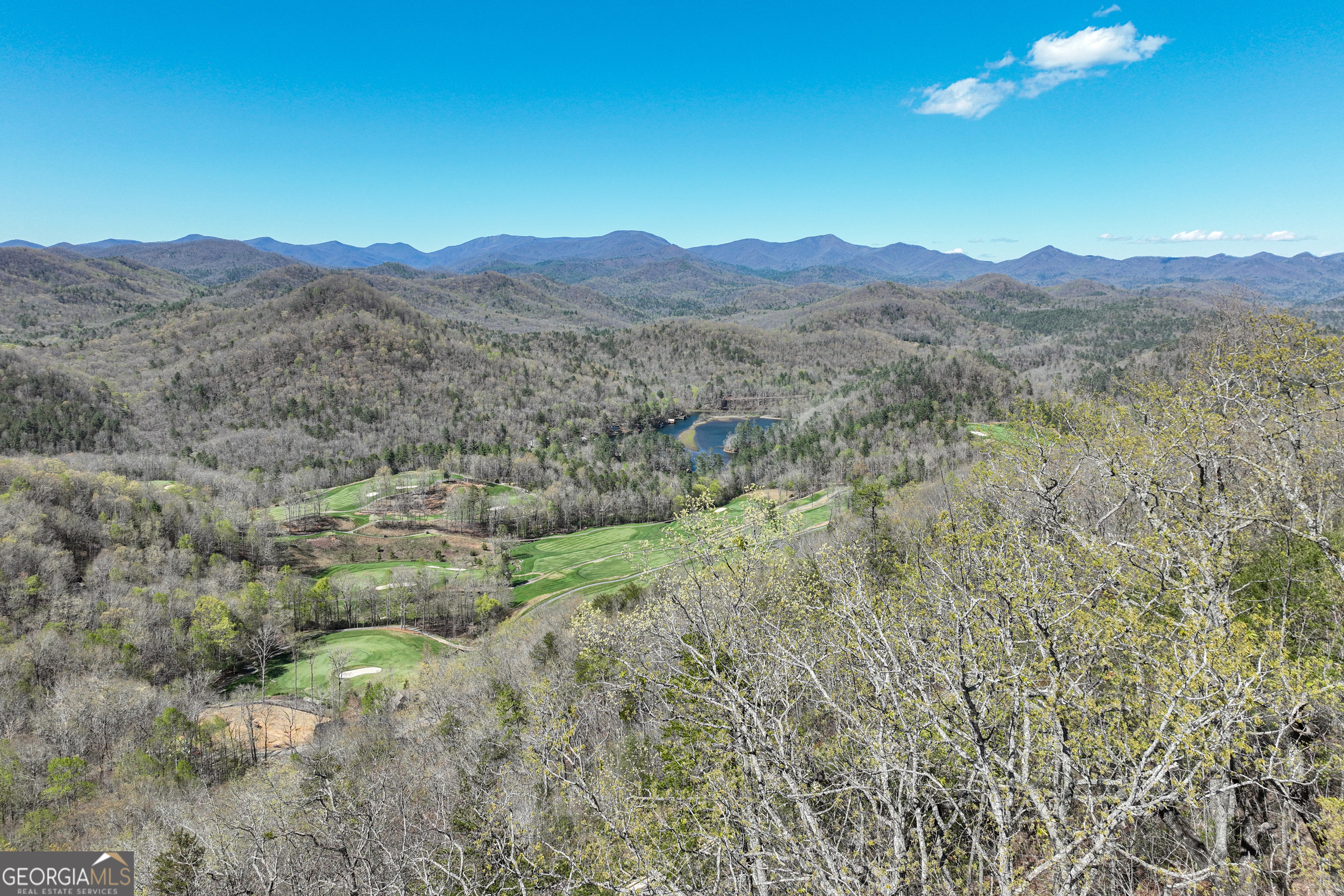 Perched high on the mountainside within the prestigious gated community of Waterfall at Lake Burton, this exceptional 0.54-acre lot offers panoramic vistas stretching across the North Georgia and North Carolina mountains. Enjoy unobstructed views over miles of Chattahoochee National Forest, the northern reaches of Lake Burton, and several fairways of the renowned Waterfall Club golf course. The lot's natural slope is ideal for a multi-level custom home that maximizes these breathtaking views. Key Features: Prime Location: Situated on a paved, curbed, and guttered road within a secure, gated community. Expansive Views: Overlooks Lake Burton, the Waterfall Club golf course, and the surrounding mountain ranges. Design Flexibility: No mandatory timeline to build; bring your own Georgia-licensed builder. Architectural Oversight: All home designs are subject to approval by the community's Architectural Review Committee, ensuring quality and cohesion. Adjacent Opportunity: Lot C-1, directly contiguous to this property, is also available for purchase.