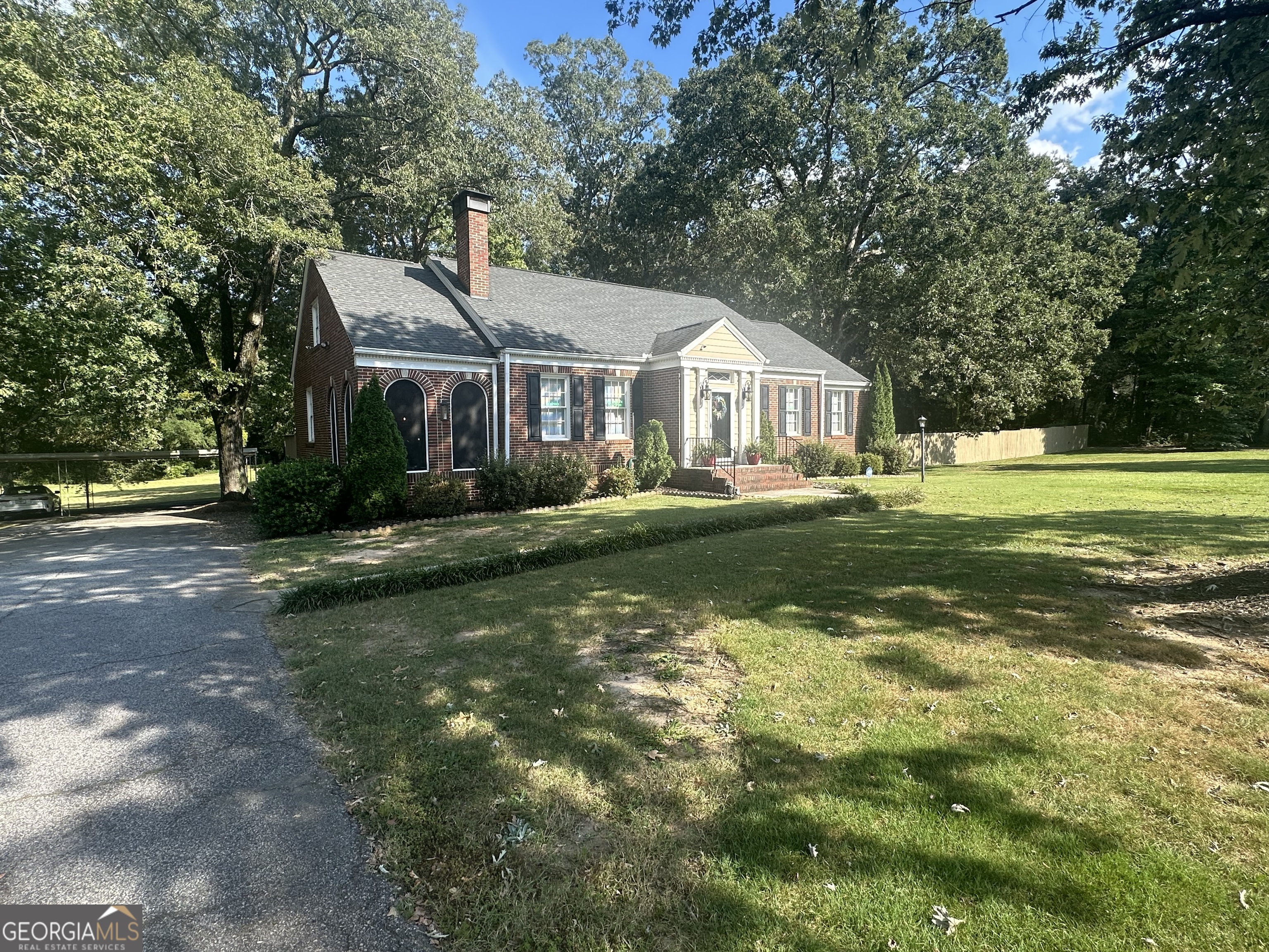 **Waiting on pictures from photographer to come in, will upload the pictures soon**Welcome to 3157 Highway 155 - a beautifully restored 4-sided brick home on 2.61 acres, partially wooded and cleared, offering endless opportunities for how you can enjoy the land. This property combines timeless charm, modern updates, and the flexibility of potential commercial use. Upstairs, the main level features an open floor plan with gleaming hardwood floors, a spacious living room with a cozy fireplace, 3 bedrooms, and 1 full bath. One bedroom doubles perfectly as a home office with its own private deck. Offering tons of storage space. The modern kitchen includes stainless steel appliances, a large island, and a walk-in pantry with plenty of storage. Start your mornings on the screened front porch and end your day in the relaxing owner's suite. The fully finished basement, with tile flooring, offers the ideal setup for an in-law suite or multi-family living. It includes 2 bedrooms, 2 full baths, its own full kitchen with stainless steel appliances and island, laundry space, and 2 separate entrances. A large concrete patio creates the perfect outdoor entertainment area. Additional highlights include a guest house with private driveway, currently rented for extra income, a detached carport, and ample storage throughout. Every inch of this home has been thoughtfully renovated in 2017, making it truly move-in ready and well kept. Just minutes from shopping, dining, and downtown Locust Grove with quick access to I-75, this property offers the perfect mix of residential comfort, investment opportunity, and commercial potential