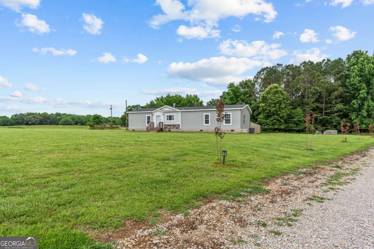 ACREAGE IN COVETED GREENE COUNTY! STOCKED POND! BEAUTIFUL NEW HOME! This is an amazing chance to grab your piece of the peaceful pie! Truly beautiful manufactured home with the most amazing open and luxurious floorplan. Kitchen will knock your socks off - generous cabinetry, abundant counter space, pot filler, stainless appliances, gorgeous lighting, lots of special touches throughout. Amazing primary suite with incredible walk-in shower, double vanity and closet space galore. Huge open great room with fireplace. Deck overlooking fenced yard. New everything (because it's new!) and sooo special! Almost 9 acres of Greene County goodness! Super close to Lake Oconee! Boat ramp. Access within 2 miles! Level fenced yard for dogs/kids - beautiful shared stocked pond- the best of all worlds!