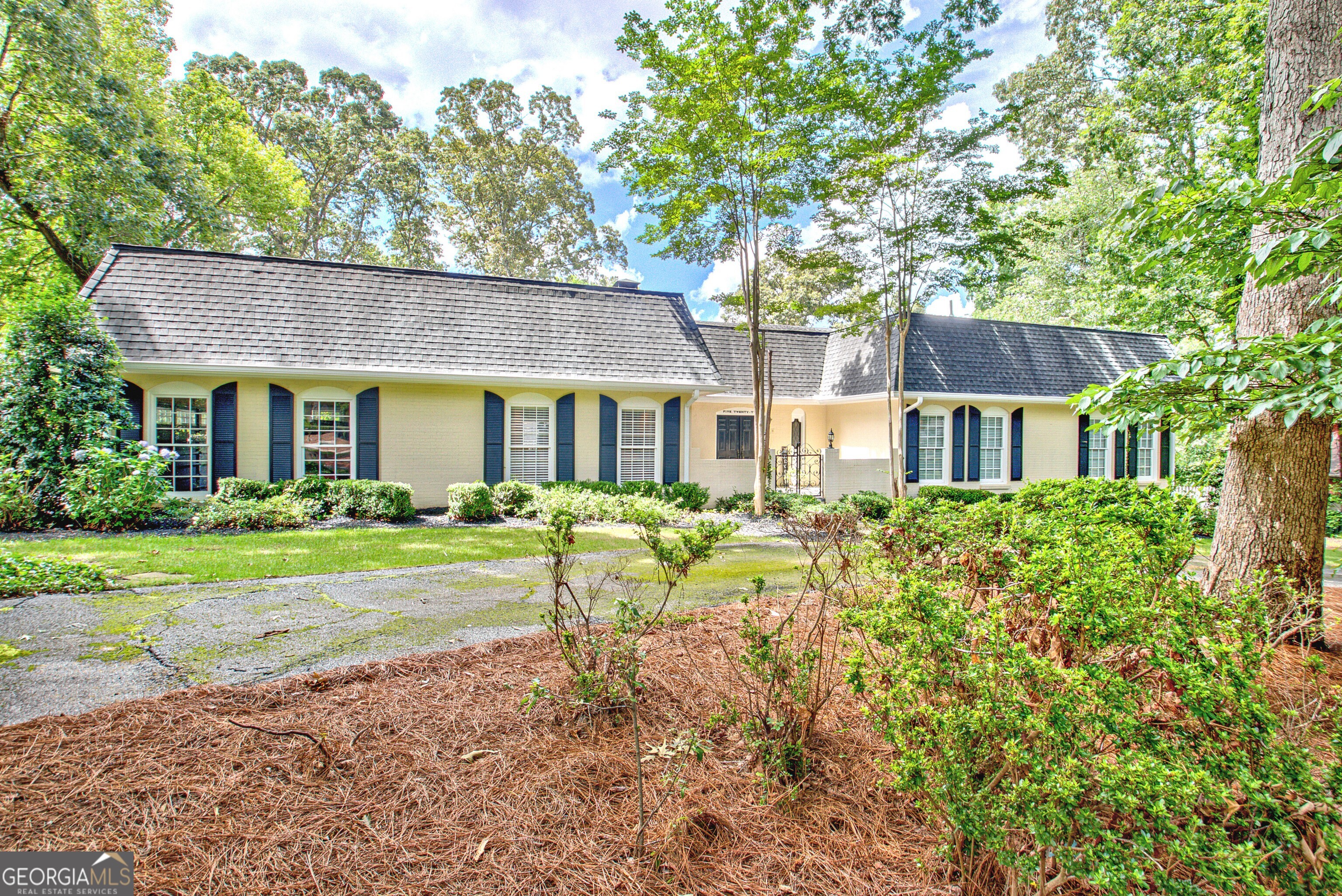 This classic brick ranch with a pool and an amazing view of Flat Creek's Homestead golf course offers the rare opportunity to enjoy mid-century elegance and modern comfort! From the moment you approach the formal entry court, with its circular drive, wrought iron gate, natural flagstone, fountain, and elegantly inscribed with "Five Twenty-Two" above the double front doors, you'll sense the thoughtful design and enduring charm that define this beautiful, completely updated home. Inside, a lovely foyer welcomes you through to a large living room with French doors that open to a vaulted sunroom with warm wood-paneled ceilings, expansive windows, and abundant natural light, overlooking a large new deck, and the fenced back yard sanctuary with its lush, attractive landscaping, a beautifully maintained heated pool, a large terrace level patio with a hot tub, a storage shed, and another delightful outbuilding offering potential as a studio, pool house, or gardening shed. Back inside, the kitchen blends form and function with quartz countertops, stainless steel appliances, a large elegant island, abundant cabinetry and countertops, and designer backsplash and lighting. In the primary suite, the spa-like primary bathroom features a freestanding clawfoot tub, walk-in shower, elegant marble accents, and herringbone flooring, offering both luxury and tranquility. Downstairs on the lower level you will find a large recreation/ living room with built-ins and a fireplace, along with a beautiful bedroom and full bath, the large laundry room, a bonus area perfect for a gym, playroom, quiet office, home theater, or additional living space, and a workshop/storage area ideal for tools and hobbies. Set within the quiet, well-established neighborhood of Golfview, and just minutes from shopping, dining, great schools, and parks, and easy access to the Atlanta airport, 522 Golfview Drive has everything you're looking for, and more!
