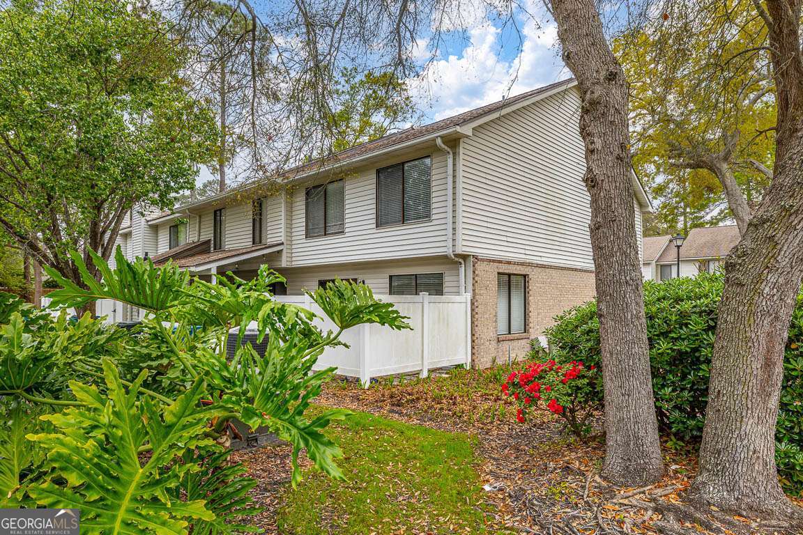 Welcome to this beautiful END unit condo in the heart of the south end of St. Simons Island! This sought after complex is one you don't want to miss seeing. The updated kitchen offers custom cabinetry, quartz countertops, tile backsplash, and stainless appliances. The flexibility of this floorplan offers bothva den with a wood burning fireplace, breakfast area with an exterior door open to the porch and yard area (also fenced), powder room, and a great room with a spacious dining area. Upstairs has 3 spacious bedrooms with two full baths and tons of closet space. With tennis and pickleball courts, a dog park, sports fields, playground, shopping, dining, fishing pier, live music venues, and the beach just minutes away experience the best of a St. Simons Island lifestyle! Realtor created a beachy vibe by virutally staging!