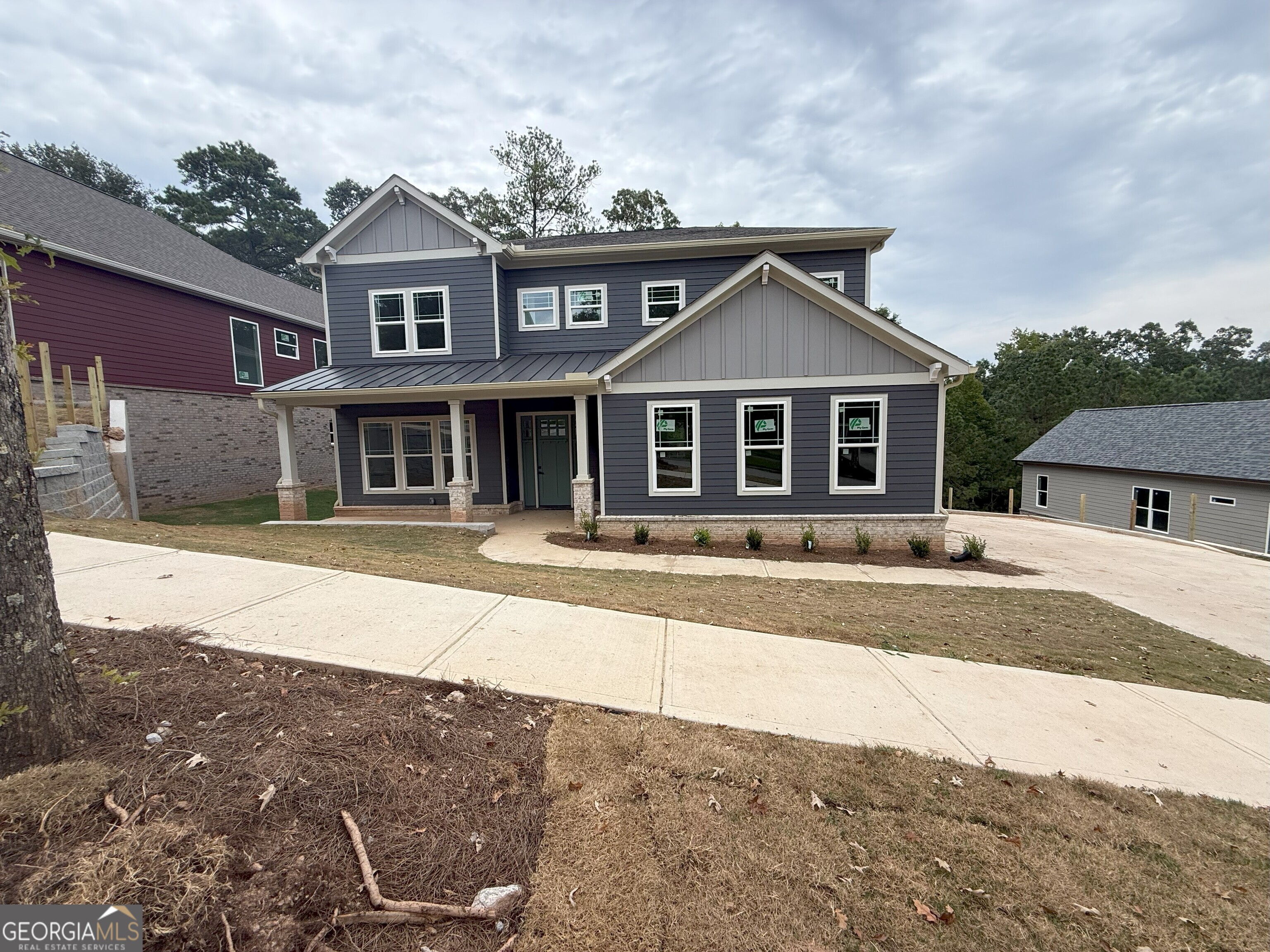 Professional photos coming tnext week. Showings will open up on 9/9/25 Seller and preferred lender are contributing to buy down your rate to 4.99%for qualified buyers! Plus, enjoy peace of mind with a 2-10 home warranty. Even better - homes of this quality are typically priced at least $20 more per square foot, making this an incredible value opportunity. Seller also has 6 additional lots available in Tributary at New Manchester 4 of which have not started construction yet and 5 homes under construction in Tributary at The Villages. Step into refined living at this two-story modern craftsman, where thoughtful design meets luxury finishes. A dramatic two-story family room welcomes you with natural light, open flow, and stunning details, while the formal dining room adds elegance for gatherings. The chef's kitchen features an oversized quartz island with sink, 8-foot tall cabinets, stainless vent hood, tile backsplash, pendant lights, and a butler's pantry. Wide plank wood flooring, 10-foot ceilings, and 8-foot doors throughout complete the upscale feel. This home is designed for flexibility and multi-generational living with junior master/in-law suite on the main level with its own washer/dryer hookups and private balcony. You also have an upstairs master retreat with his & hers bathrooms, a large flex space, and your own private balcony. Every bedroom is oversized with spa-inspired ensuite baths featuring quartz counters, frameless glass showers, anti-fog mirrors, and tile showers. Additional highlights include a tiled laundry with sink, LED lighting, a private rear deck, and an unfinished basement stubbed for a bath, ready for your custom vision. Set on a .38-acre lot near Lions Gate in Douglasville, the Tributary subdivision has sidewalks, community swimming pool with tennis courts and playground. Located minutes away you have golf, shopping, Sweetwater Creek State Park and hiking. Driving to Atlanta is an easy commute. Luxury, multi-generational flexibility, and unbeatable value - all in one remarkable home.