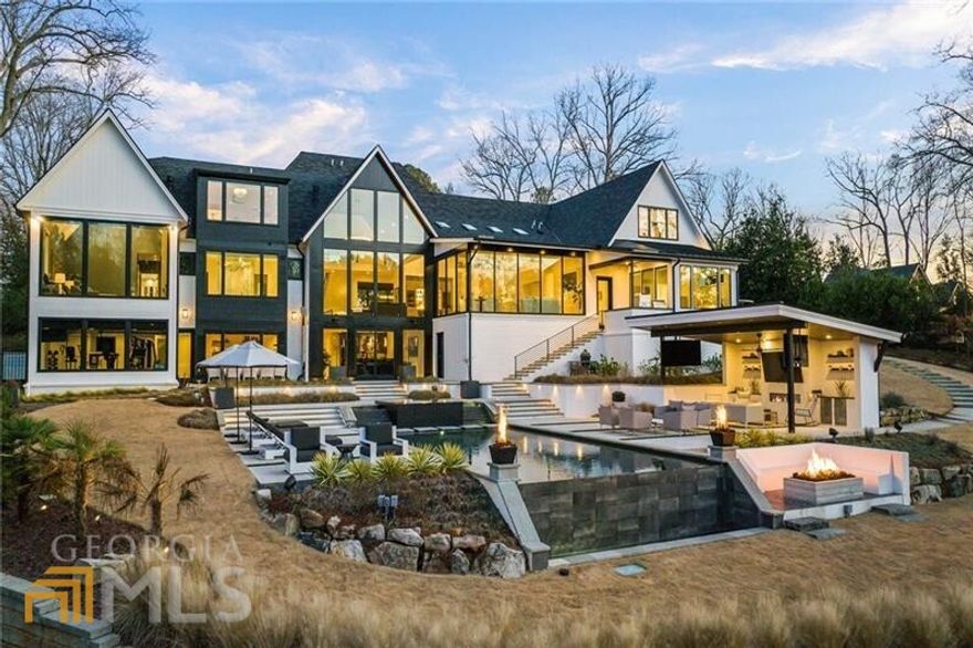 Situated on an incredible, gated golf course lot in the heart of East Cobb's Atlanta Country Club, this jaw-dropping Scandinavian-inspired modern masterpiece impresses with every turn. Enter through a large glass pivoting door into the two-story foyer, which offers a sightline of the award-winning backyard, infinity-edge pool, and outdoor living areas. Warm hardwood floors flow seamlessly into the two-story fireside great room where expansive sheets of glass frame the captivating golf course views. A beautiful backlit onyx bar area adds drama in the conversation area connecting the great room to the high-end modern kitchen. Sleek cabinetry, integrated appliances, quartz countertops with subtle veining and an island with a double waterfall edge work in tandem to create a magazine-worthy chef's paradise. Providing a more intimate space for everyday living, the adjacent family room and casual dining area boasts floor-to-ceiling windows and a wood-lined shed ceiling with Mid-Century-inspired beams. A scullery with a huge walk-in pantry is located off the kitchen alongside the gorgeous dining room with automated draperies and window shades. A glass-front temperature-controlled wine cellar adds visual interest to the open hallway off the sophisticated dining room. A conveniently located main-level laundry is accessed from the mudroom, as well as a built-in workstation and access to the three-car garage. Enrapture in the oversized main-level primary suite, offering cathedral ceilings, a large sitting area, motorized shades, and perimeter recessed lighting. Relax and unwind in the beautiful spa-inspired en suite bathroom, complete with separate vanities, separate water closets, a central seamless glass steam shower, a freestanding bathtub, heated floors, and an enviable custom-built closet. A luxurious guest suite, separate powder room, and a grilling porch complete the main level. Upstairs offers two impressive junior suites, each with sitting areas and luxury en suite bathrooms, a third en suite guest bedroom, and a landing area with morning bar. Perfect for entertaining, the living spaces continue on the terrace level, which includes a game area, recreation room, handsome bar, a theater, an office, a full bathroom, and a fitness studio. The walkout terrace level leads to the award-winning backyard, which is truly breathtaking. A sprawling terrace overlooks the spillover spa, infinity-edge pool, sundecks, cabana, fire pit, and golf course. Relax poolside under the covered cabana, complete with three mounted TVs and an outdoor fireplace flanked by refrigeration and storage. A sunken gas fire pit is surrounded by a built-in bench and overlooks the golf course as additional fire features add drama to the landscape. Vacation every day at 660 Atlanta Country Club Drive.