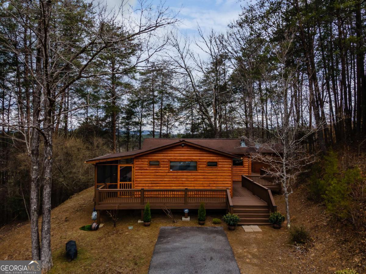 Walk to the Toccoa River, soak in the hot tub, or cozy up by the fireplaces-this furnished 2BR/2BA Mineral Bluff cabin has it all! Short Term Rental approved + priced to sell-just 2 minutes from Ron Henry Horseshoe Bend Park. Blending rustic character with modern comfort, this home is perfect as a weekend getaway, vacation rental, or full-time retreat. You'll be just 5 minutes from McCaysville/Copperhill's restaurants, shops, and entertainment, & 20 mins+- to the historic streets of downtown Blue Ridge. Inside: Warm and inviting hardwood floors + tongue & groove walls throughout; Light-filled open-concept living area with wood-burning fireplace; Spacious primary suite with room for a reading nook, Pilates mat or cozy daybed; Ensuite baths in both bedrooms for privacy and convenience. Outside: Expansive wraparound decks with mountain views and multiple spots for outdoor living space & entertaining. A unique screened-in summerhouse with TV and wood-burning fireplace-perfect for lounging, entertaining, or even extra sleeping space year-round. Covered hot tub oasis to relax after mountain adventures, fishing, or tubing on the Toccoa. Bonus: This cabin comes fully furnished-yes, even the float tubes-so you can start enjoying it from day one! With its unbeatable location, turnkey setup, and approval for short-term rentals, this is an opportunity that won't last long. Paved road access & ample parking! Schedule your showing today and start living the North Georgia mountain lifestyle!