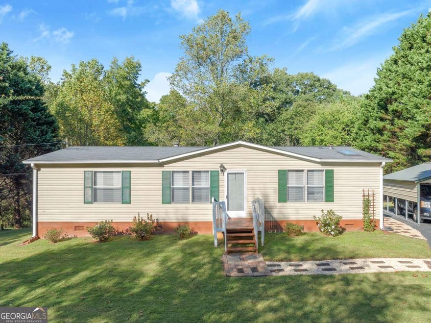 Perfectly maintained 3-bedroom, 2-bathroom home on just over one acre lot within the highly sought-after East Forsyth School district! This home offers a spacious and inviting floor plan with a cozy living area with a fireplace, a nice kitchen with plenty of cabinet space, and a comfortable primary suite with a private bath. Many recent updates include a new HVAC system, water heater, flooring, and walk-in shower in the primary suite. Two large carports and a shed provide areas for vehicles or a workshop. Enjoy peaceful country living with plenty of room for outdoor activities, gardening, or future improvements. Located just minutes from shopping, dining, and Lake Lanier, this property combines privacy and convenience. Move-in ready and well cared for-don't miss your chance to make this one your own!