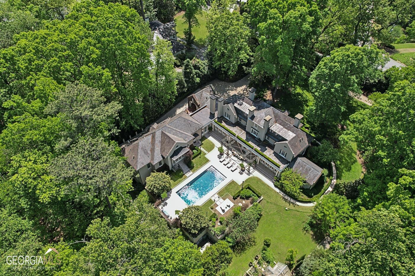 Spanning 2.68 acres, completely private and enclosed, this property is truly in a class of its own. Entirely unique and meticulously crafted by hand, it is exquisite on every level. Located in one of the very best neighborhoods, in one of the best parts, of one of the best streets, where Blackland Road meets Tuxedo Road, you are surrounded by babbling brooks, rolling hills and tall trees, but also nearby the cultural and city conveniences of Buckhead, Atlanta. Designed by Philip Shutze, one of Atlanta's most beloved architects of the 20th century, and recently remastered by Stan Dixon, this home is a humanist architecture masterpiece reminiscent of the Italian villas that inspired Shutzes' work and that set the tone for Atlanta's most beautiful residential neighborhoods. Bespoke interiors, designed by internationally acclaimed interior designer Tammy Connor, include custom fabrics and drapery, intricate stone and wood work, naturally patinated brass fixtures and custom cabinetry with luxurious hardware. Delightful surprises are found throughout the home, including a cheeky prohibition bar, hidden guest rooms and smartly tucked away staff and nannies' quarters. Additional features that make the home so livable and adapted to today's lifestyle include a lovely butler's kitchen/panrty, a sunny breakfast room with patio, an over-sized laundry room, multiple studies and home offices, and plenty of outdoor entertaining areas. Built solidly over a piece of natural granite and made modern with sustainable principles in mind, this home also lives lightly on the Earth, using a geo-thermal heating and cooling system, a water reclamation and storage system and building materials that will last for generations to come. An over-sized three car-garage with Tesla and Porsche electric car charging stations, HVAC, Control4 security system, a golf cart/workshop garage and additional parking for 9 vehicles complete the terrace level features. Beyond the pool area, there is an English greenhouse, designed by Hartley Botanic, a whimsical treehouse and a glass cabin with a wood burning stove and built with local reclaimed hardwoods. Each detail inside and out has been thought through and executed flawlessly for a timeless, elegant and welcoming effect.