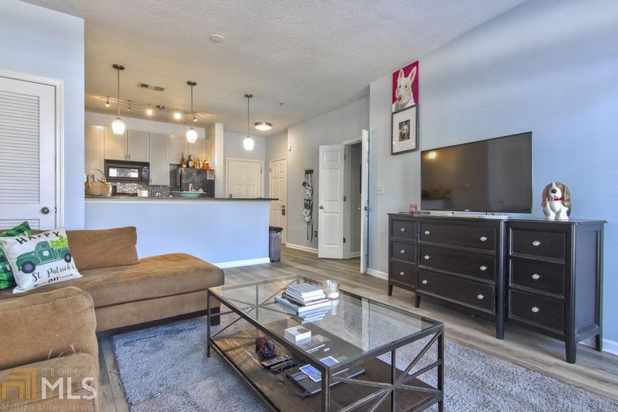 Fall in love with this ultra convenient ground floor unit right across from the park and all that bustling Atlantic Station has to offer! Enjoy dual access to Unit 1147 from inside the building OR from your park-side patio. New flooring carries throughout the open main living areas including kitchen with breakfast bar, granite, tile backsplash + pantry. Well-sized bedroom is bright and accompanied by an updated bath with lots of storage, garden tub + walk-in closet. Fantastic building amenities include gym, sauna, pool, clubhouse, business center and more! Be at home in the middle of it all for under $200K!