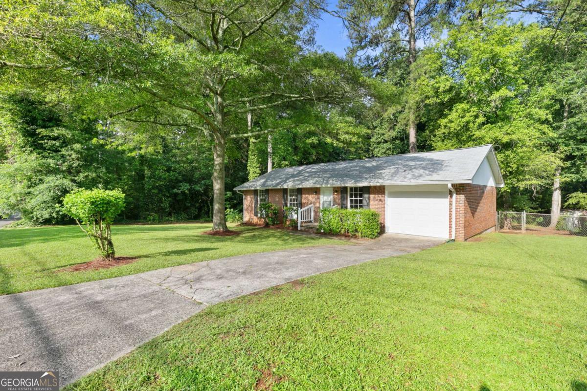 As we step into 6671 Gano Drive, let me show you why this one stands out. This 3-bedroom, 2-bathroom brick ranch has been meticulously maintained and thoughtfully updated, offering a blend of charm, comfort, and peace of mind that's hard to come by. Right away, you'll notice the curb appeal - that classic four-sided brick and the privacy of a tree-lined lot. Walk around back and you'll find a fully fenced yard and a quiet creek that runs along and behind the property - it's peaceful, calming, and gives the home a tucked-away feeling that's rare, especially with no HOA. Now step inside. One of the first things you'll see are the beautifully refinished hardwood floors, bringing warmth and character to every room. The natural light hits just right, especially with the fresh paint and updated lighting throughout. Every light fixture, every door handle, every detail has been chosen to create a clean, inviting space. The kitchen has been updated with gorgeous new granite countertops and is perfectly set up for both everyday living and hosting - whether you're prepping dinner or chatting with guests while you cook. Down the hall, there are two comfortable guest bedrooms, an updated guest bathroom, and the primary suite, which features its own private bath - both bathrooms have been updated with new tile work and modern finishes, along with durable vinyl flooring for a sleek, low-maintenance touch. The updates don't stop at what you can see. Behind the scenes, the home features a newly installed AC system, a newer roof, new garage door, added attic insulation, and a full moisture barrier in the crawlspace - all part of the effort to keep the home running efficiently and protected from top to bottom. A whole-home security system is already in place for added peace of mind. This home isn't just move-in ready - it's been loved and looked after, and it shows. And if you need to commute or travel, you're less than 20 minutes from both the Atlanta airport and downtown - so convenience is never a question. 6671 Gano Drive isn't just a house - it's the kind of place that feels like home from the moment you step inside. I'd love for you to experience it in person. Let's schedule your private tour and see if this is the one you've been waiting for.