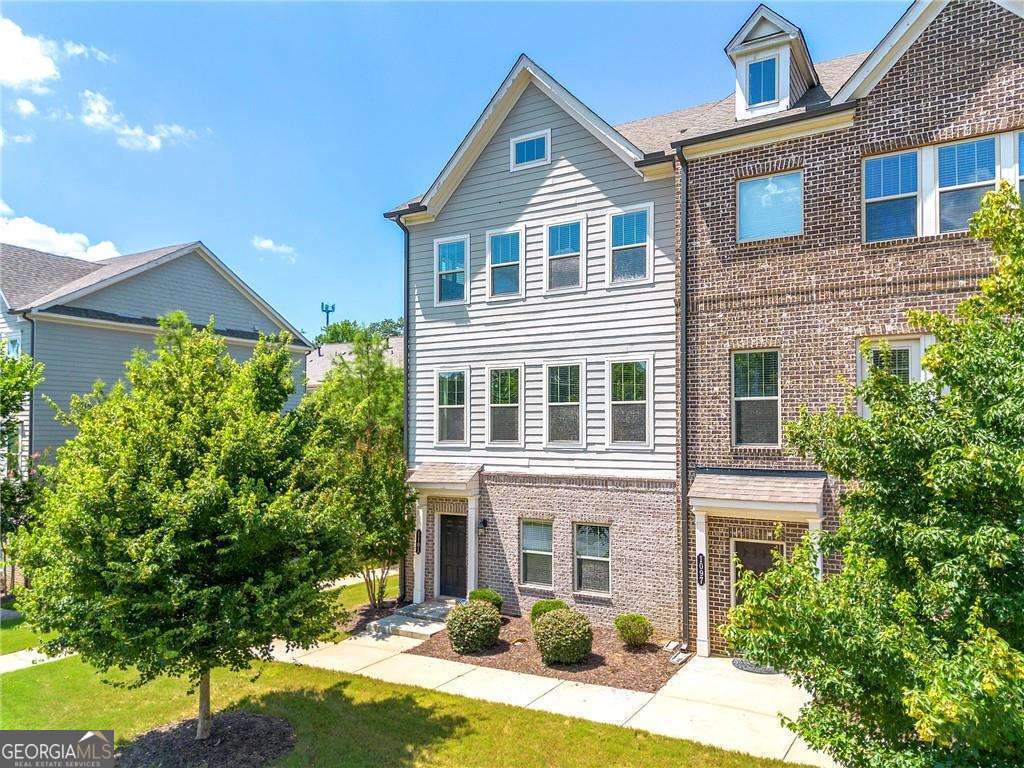 Welcome to Concord Trails in the highly sought after Cobb school district! This end-unit townhome situated on a quiet cul-de-sac features impressive views from front, rear, and side windows. The home has three levels boasting over 2300 square feet. Upon entering you are greeted by a spacious two-story foyer featuring overhead windows for plenty of natural light. This home features beautiful, warm hardwood flooring throughout! The kitchen is a chef's dream, featuring stainless steel appliances, stone countertops, and a stunning oversized kitchen island, complete with bar seating for casual meals or a quick snack. The open-concept layout seamlessly flows into the dining/living and family room areas, making it perfect for entertaining guests or enjoying some family time at home. Just upstairs, the second level hosts three bedrooms including your spacious owner's suite with a luxurious ensuite bathroom and walk-in closets. The lower level, featuring one bedroom and one bathroom, is perfect for your home office, guest room or in-law space. Additional features of the home include a wonderful sunroom on the main level, a two-car garage with rear parking, an upper level laundry room, and a private balcony with peaceful views. This townhome community is located just steps away from the Silver Comet Trail (one of GA's most sought-after trails for running, walking, cycling, and more), shopping, dining, and entertainment, and provides easy access to major highways, making it an ideal location for those who need to commute. Don't miss out on the opportunity to make this stunning townhome yours!