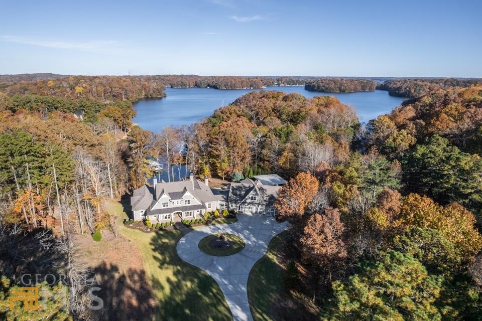 Beautiful Luxury estate located waterfront on Lake Lanier! Sitting on 3.7 acres, an extravagant property that includes 7 bedrooms with master on the main floor, spacious guest apartment, chef's kitchen w/ Thermador appliances, secondary butler's kitchen, elegantly finished terrace, refreshing saltwater pool w/ covered living spaces, basketball court, and even RV parking! This custom lake home boasts exceptional lake views from almost every room in the house. Gentle sloped path from the home to the dock, deep water, 2 slip covered dock.