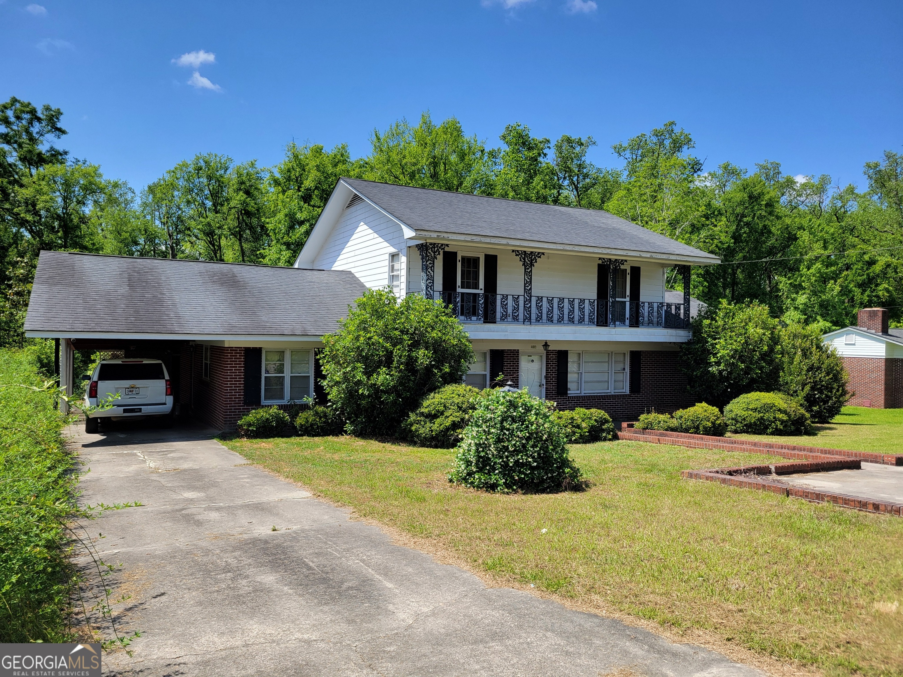 Come home to this beautifully well-built five-bedroom, three full bathroom home tucked away on a quiet street with large, peaceful wooded back yard where you will feel completely surrounded by nature! Your family will enjoy convenient carport parking and there's a street-side parking pad for guests with sidewalk that leads to the front door. Two of the upstairs bedrooms have doors that lead out onto a grand front balcony, and there's also a second story back deck with stairs leading down to the first floor covered back patio. Two CHVAC units will keep you comfortable year-round! Home features plenty of closets and storage space, as well as built in bookshelves. Formal living room and den give your family plenty of space to spread out. This one won't last long so schedule your showing of this uniquely versatile home!